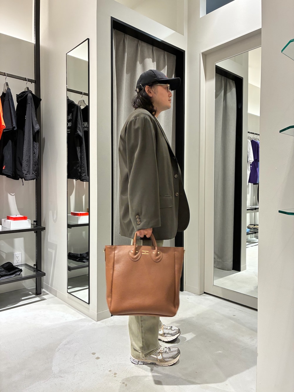 ブラウン系のテーラードジャケット、ベージュ系のデニムパンツ、ブラウン系のトートバッグを着用したメンズの夏コーディネートの2枚目の写真