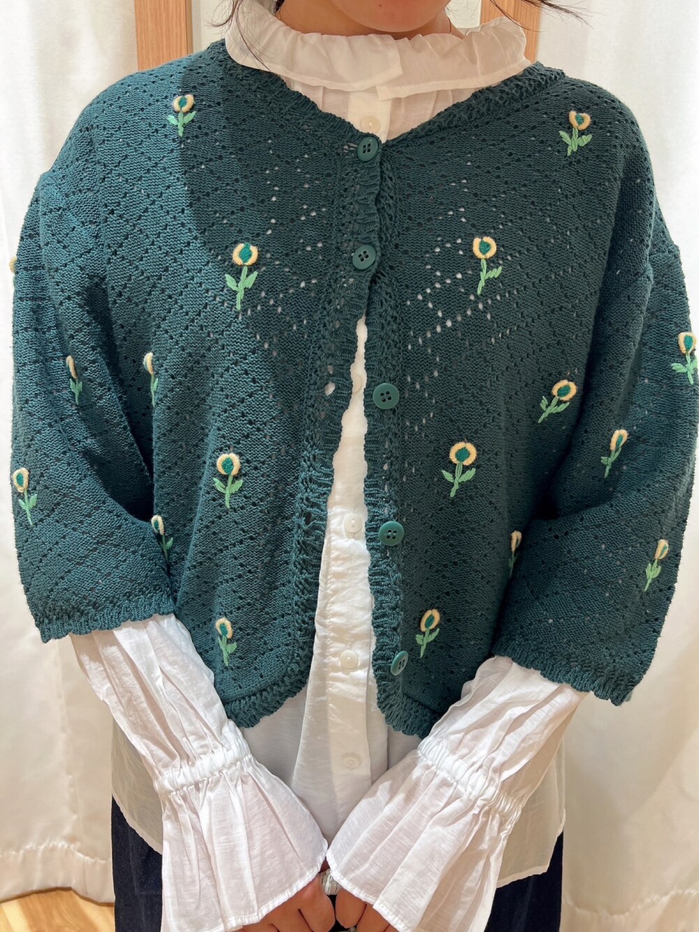 グリーン系のカーディガン/ボレロ、ホワイト系のシャツ/ブラウス、ブルー系のデニムパンツを着用したレディースの夏コーディネートの3枚目の写真