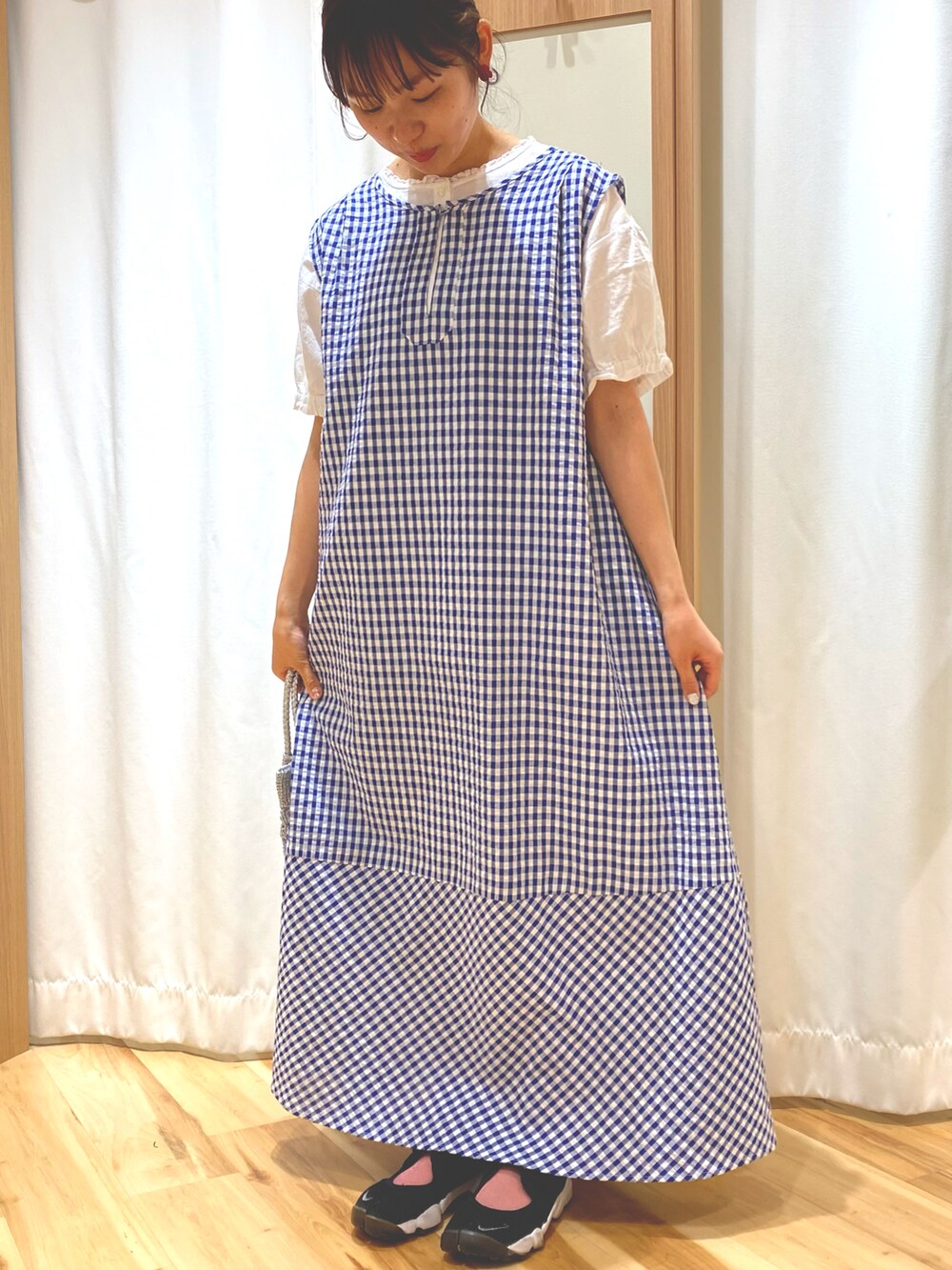 シルバー系のハンドバッグ、ブルー系のワンピース、ホワイト系のシャツ/ブラウスを着用したレディースの夏コーディネートの3枚目の写真