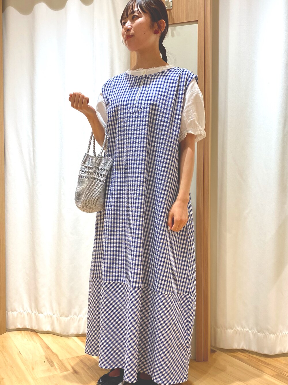 シルバー系のハンドバッグ、ブルー系のワンピース、ホワイト系のシャツ/ブラウスを着用したレディースの夏コーディネートの2枚目の写真