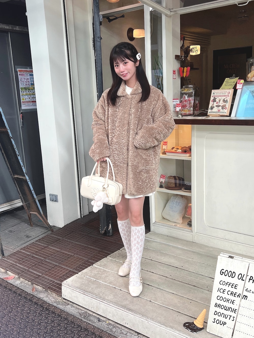 ホワイト系のカーディガン/ボレロ、ホワイト系のスカート、ホワイト系のバッグを着用したレディースの冬コーディネートの2枚目の写真