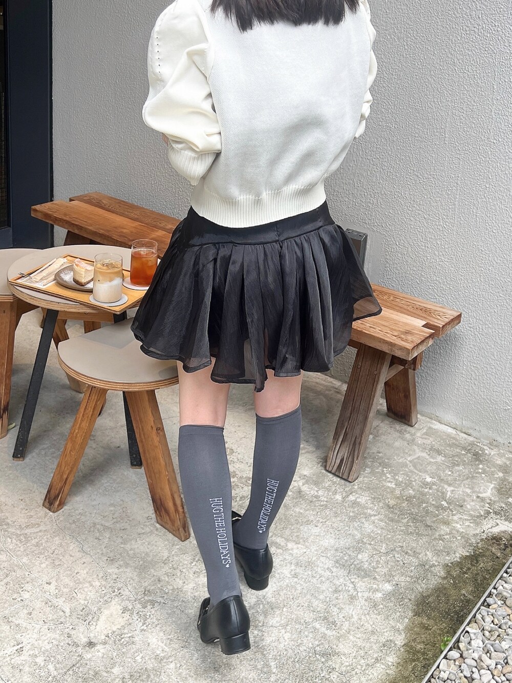 ホワイト系のトップス、ブラック系のパンツ、ブラック系のバッグを着用したレディースの秋コーディネートの2枚目の写真