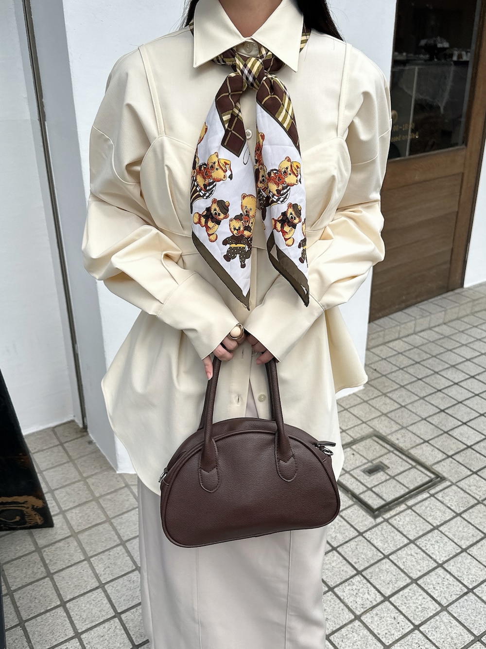 ホワイト系のシャツ/ブラウス、ホワイト系のスカート、ブラウン系のバッグを着用したレディースの秋コーディネートの2枚目の写真