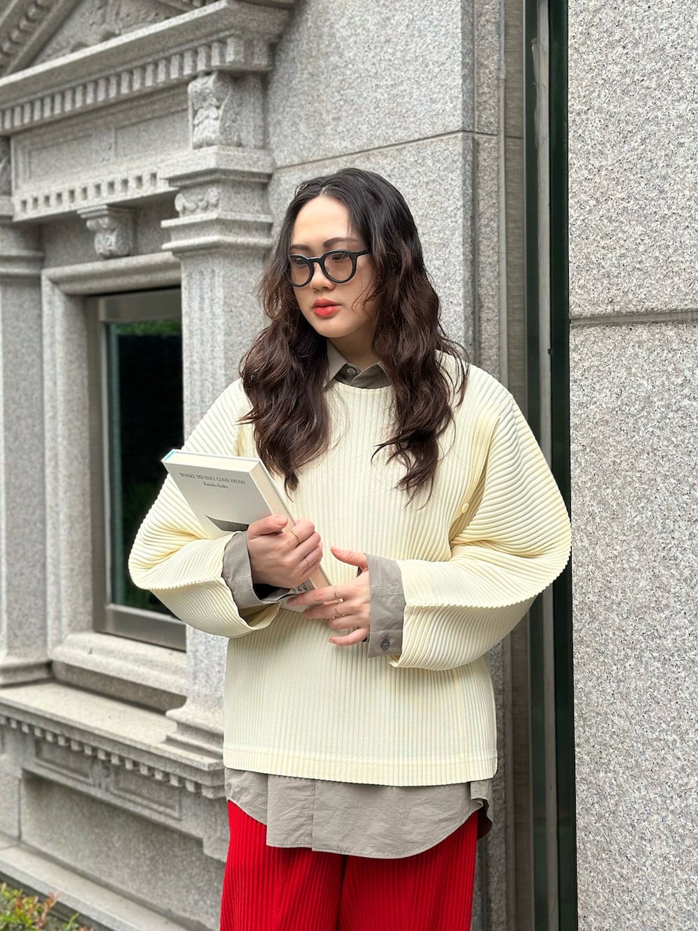 レッド系のパンツ、ベージュ系のトップス、ブラウン系のサングラスを着用したレディースの春コーディネートの2枚目の写真