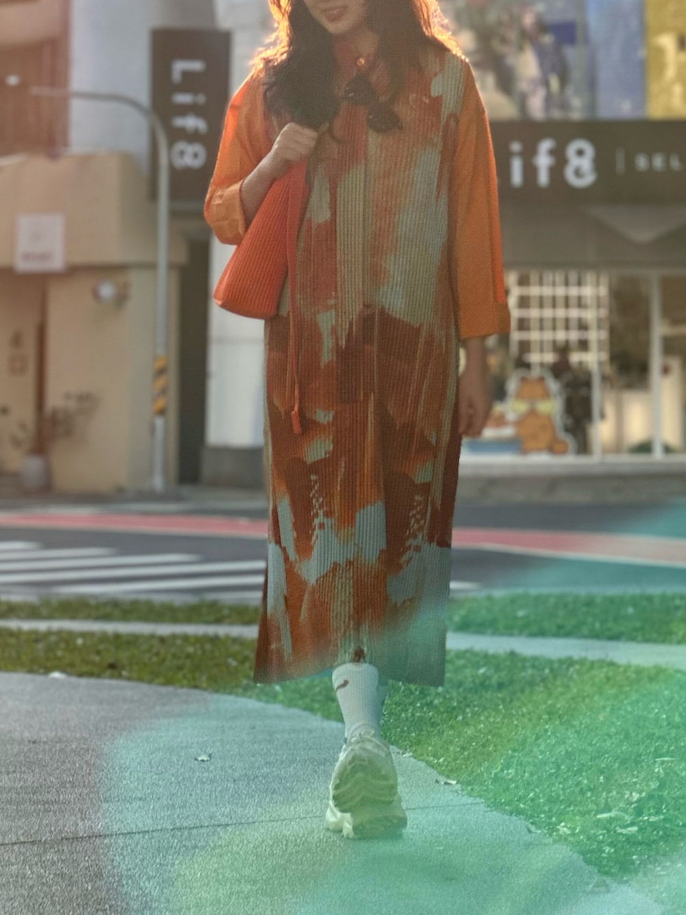 ホワイト系のシューズ、オレンジ系のジャンパースカートを着用したレディースの冬コーディネートの2枚目の写真