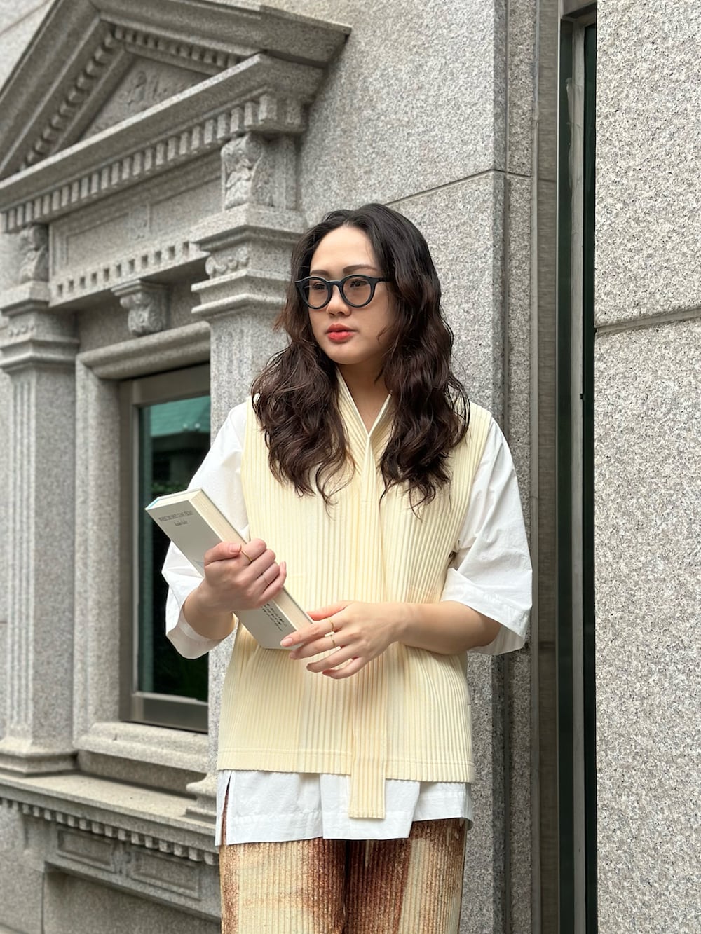 ベージュ系のタンクトップ、イエロー系のチノパンツ、ブラウン系のサングラスを着用したレディースの春コーディネートの2枚目の写真