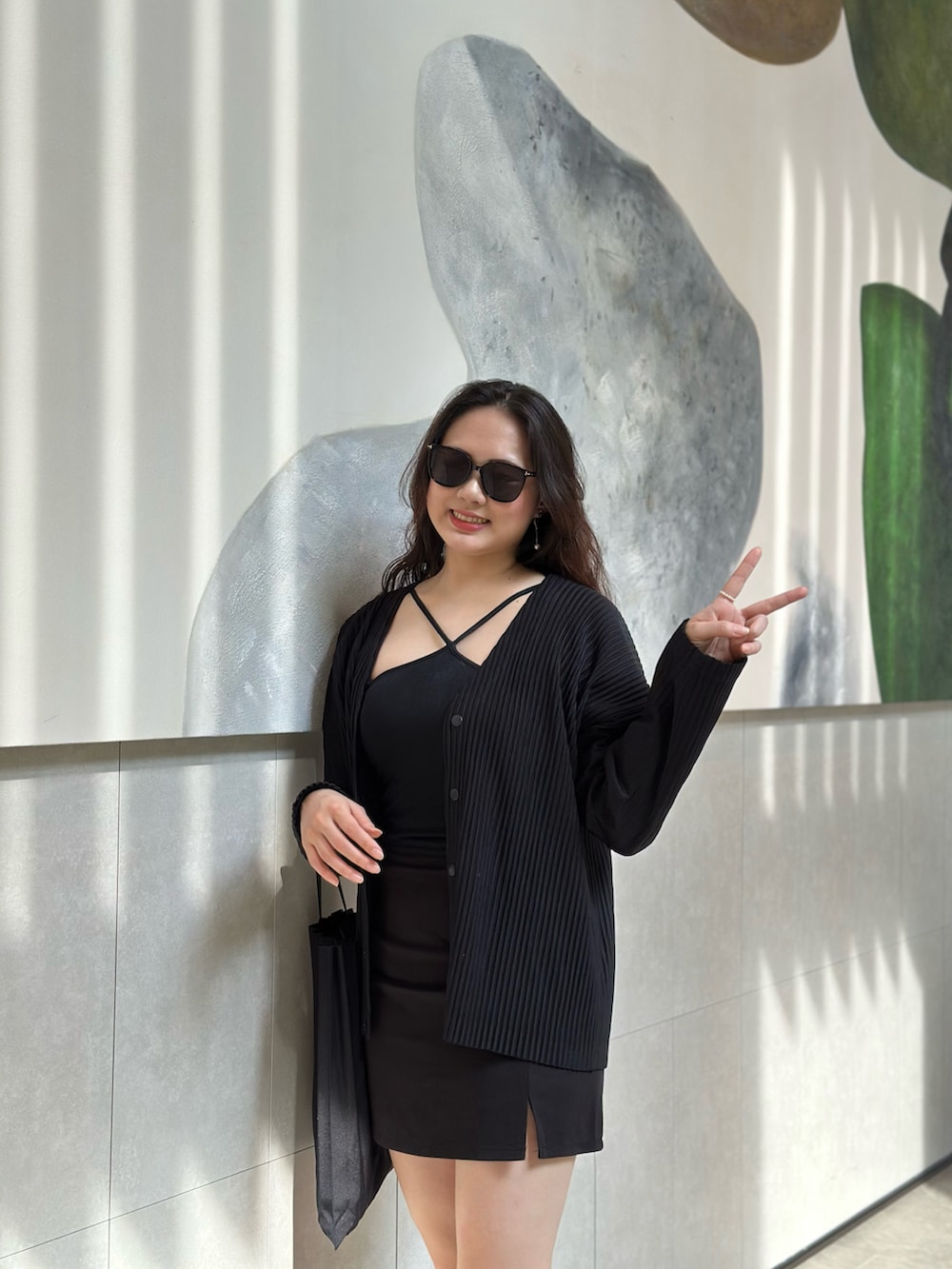 ブラック系のノーカラージャケット、ブラック系のバッグ、ブラック系のブーツを着用したレディースの春コーディネートの3枚目の写真