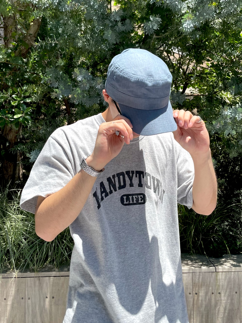 ベージュ系のブーツ、ブルー系のチノパンツ、ブルー系のキャップを着用したメンズの夏コーディネートの2枚目の写真