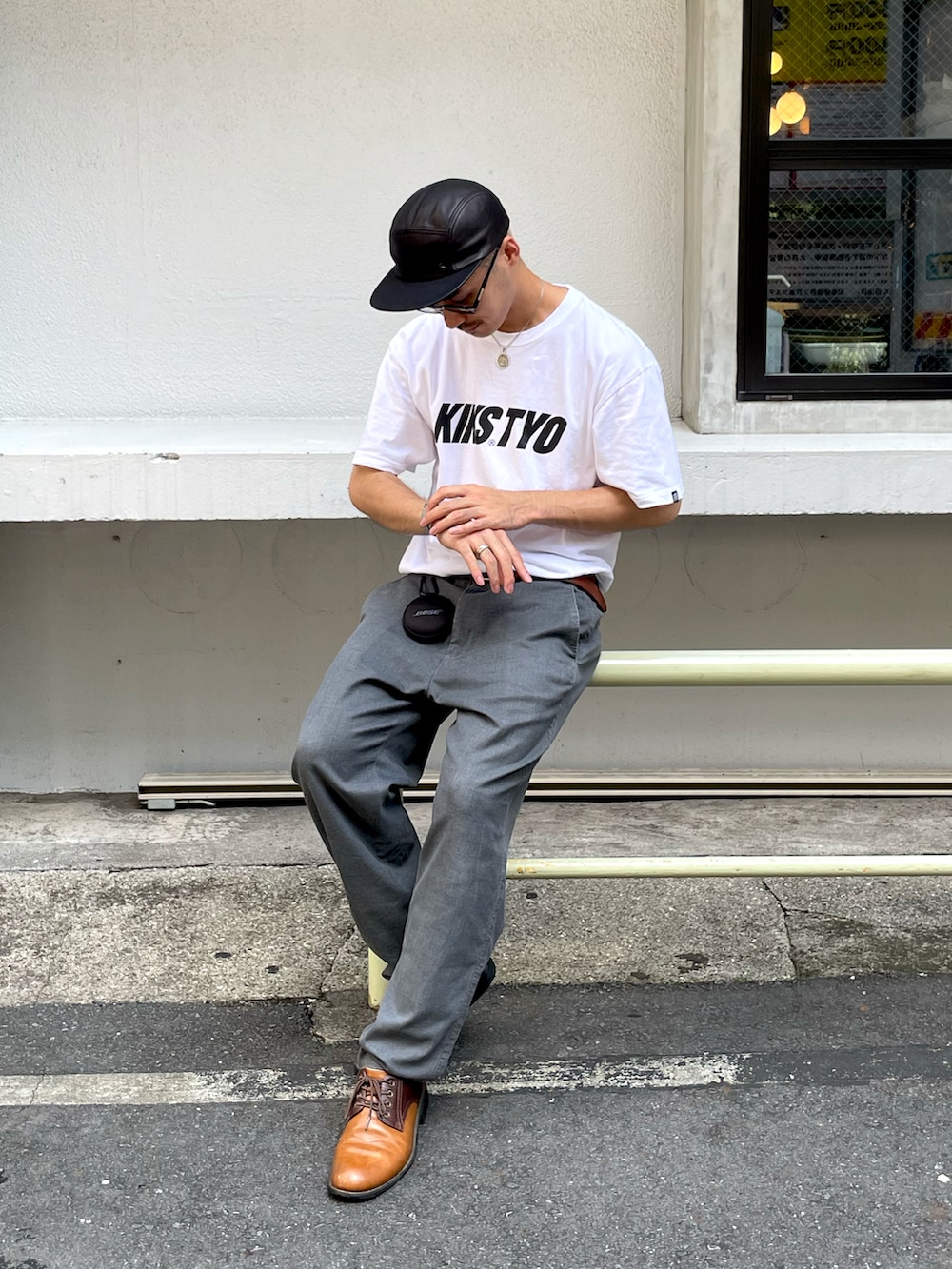 ホワイト系のTシャツ/カットソー、グレー系のスラックス、ブラウン系のシューズを着用したメンズの夏コーディネートの2枚目の写真