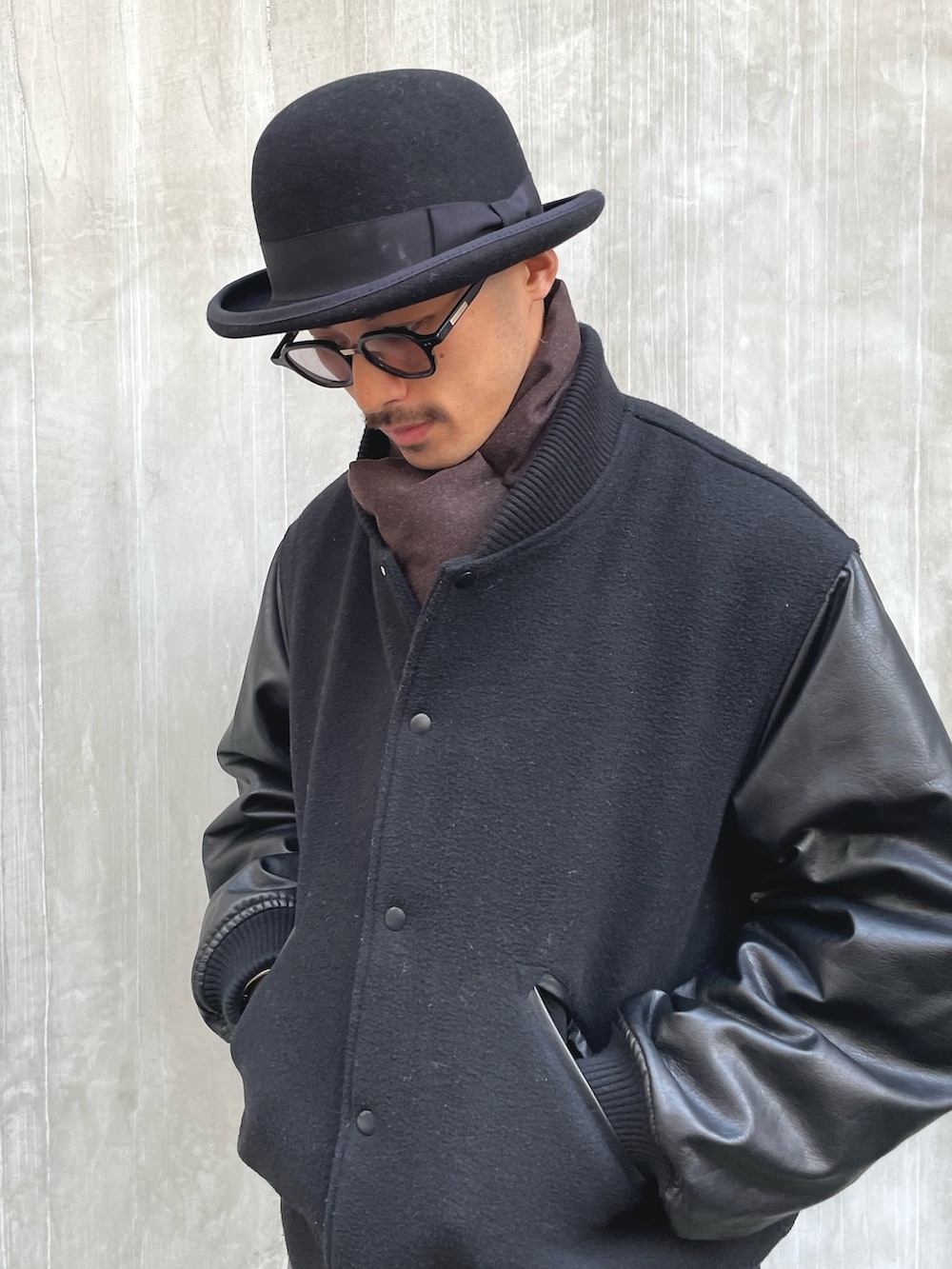 ブラック系のブルゾン、グレー系のスラックス、ブラック系のローファーを着用したメンズの冬コーディネートの2枚目の写真