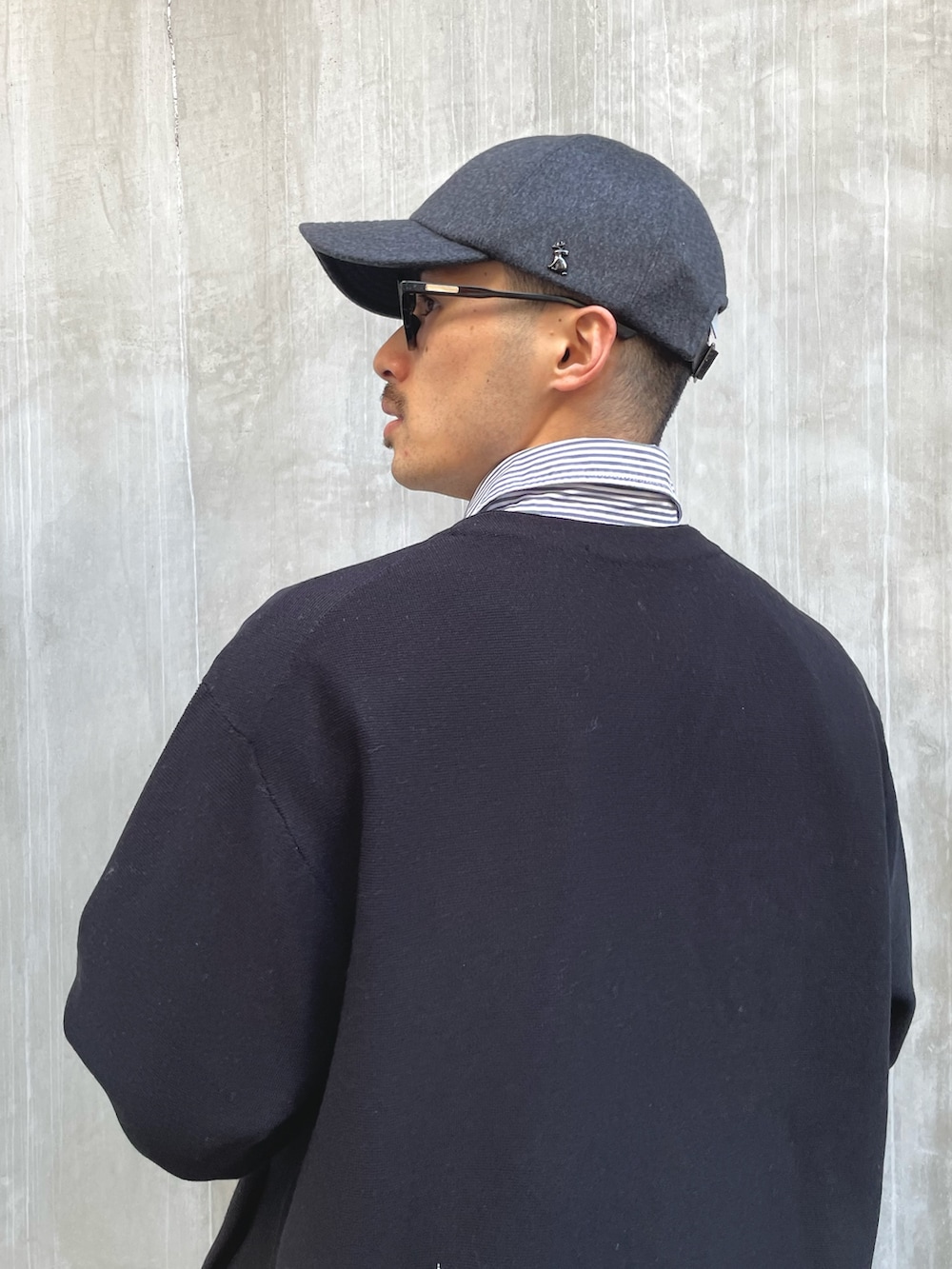 ブラック系のカーディガン/ボレロ、ブルー系のシャツ/ブラウス、ブラック系のチノパンツを着用したメンズの冬コーディネートの2枚目の写真