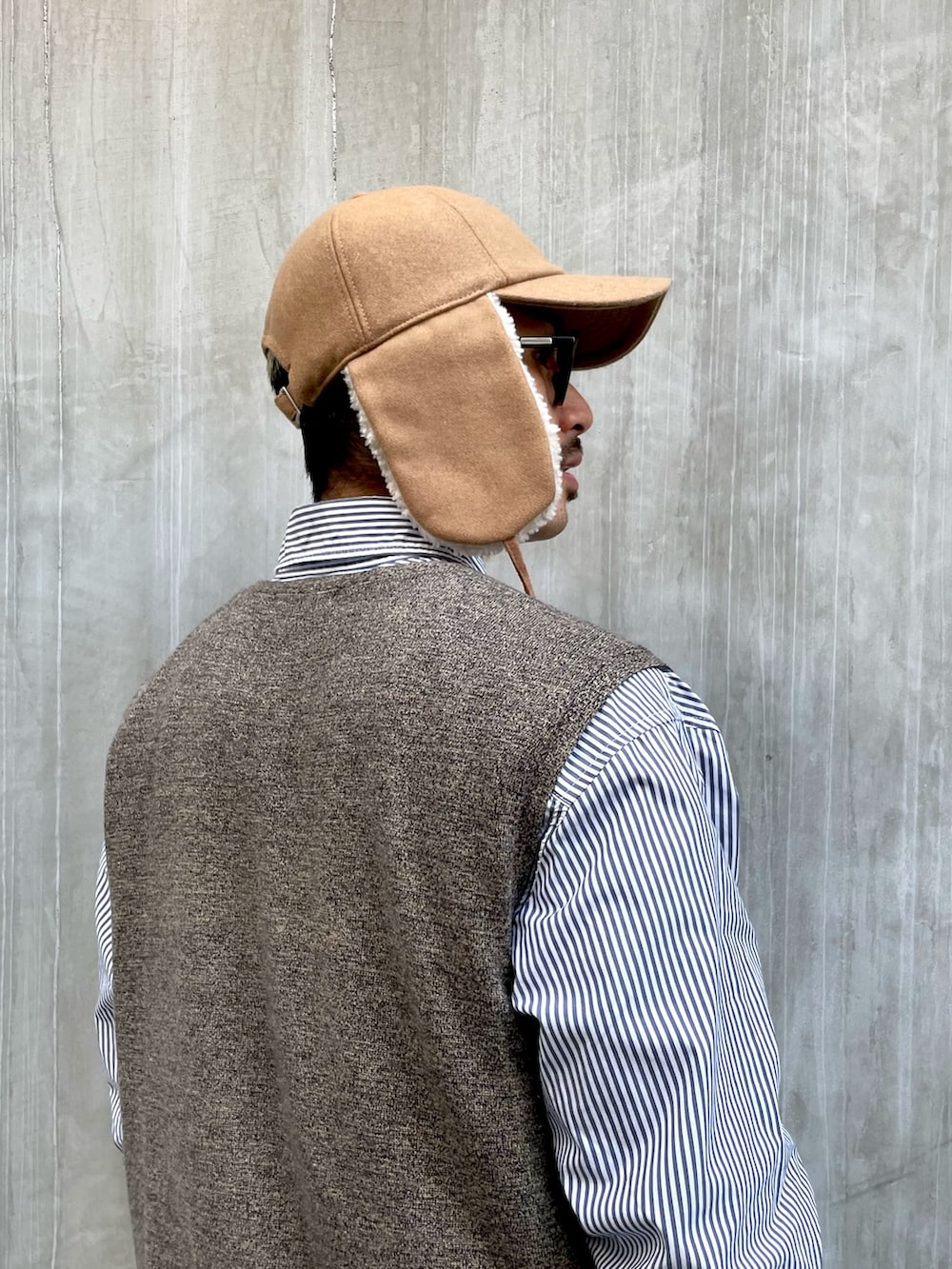 ベージュ系のベスト、ブルー系のシャツ/ブラウス、ベージュ系のチノパンツを着用したメンズの冬コーディネートの2枚目の写真