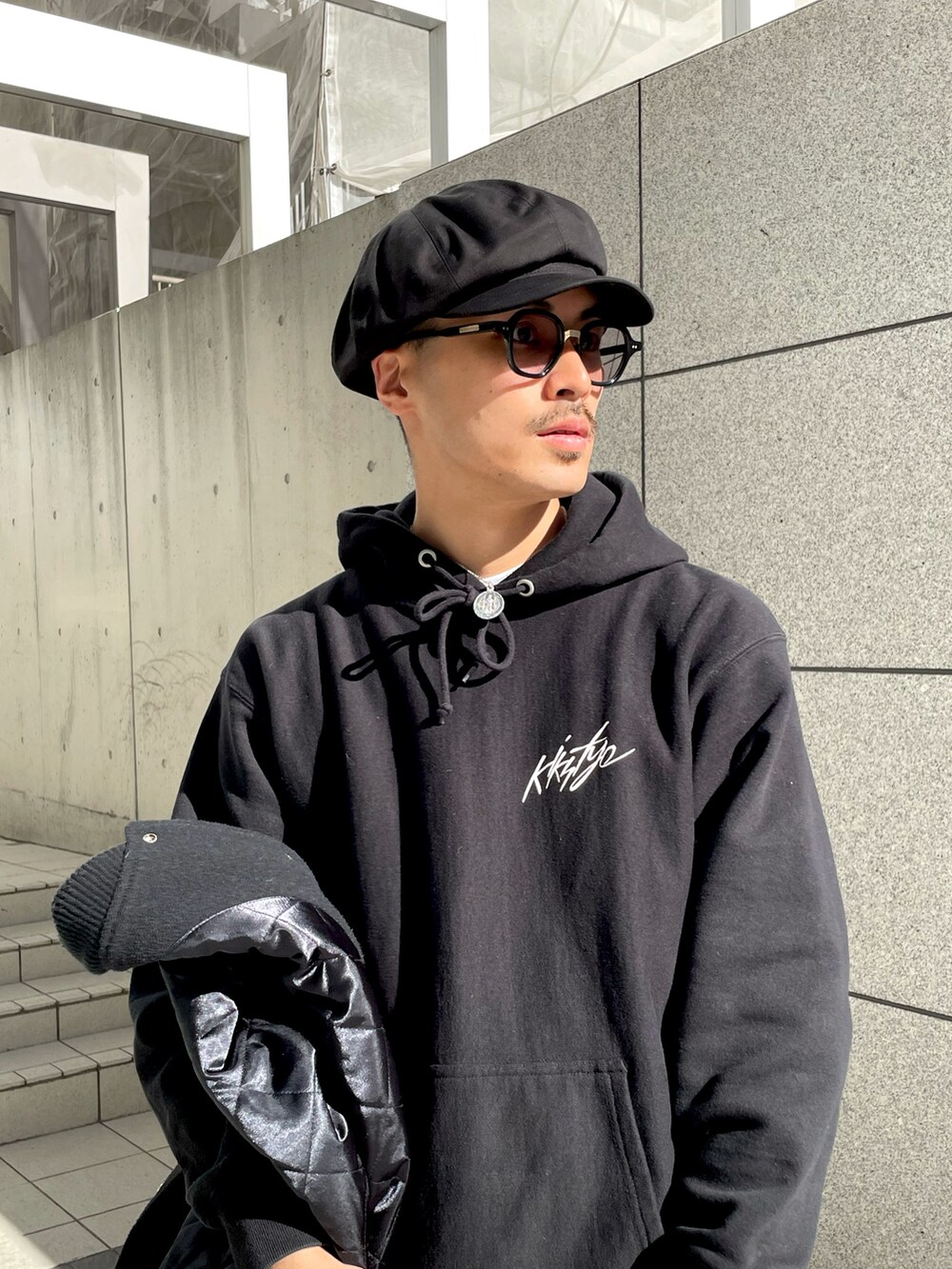 ブラック系のパーカー、グレー系のデニムパンツ、ベージュ系のローファーを着用したメンズの冬コーディネートの2枚目の写真