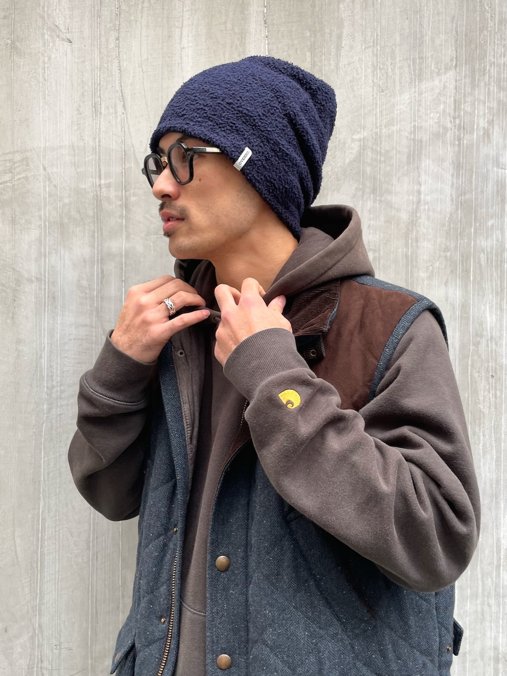 ブルー系のベスト、ブルー系のデニムパンツ、ブラック系のローファーを着用したメンズの冬コーディネートの2枚目の写真