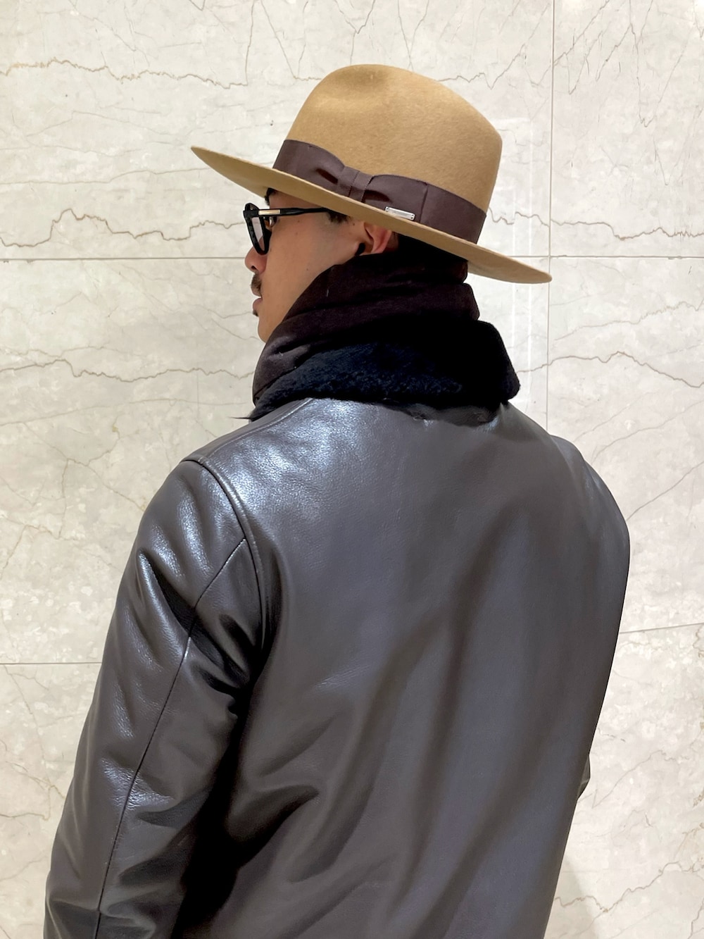 ベージュ系のチノパンツ、ベージュ系のローファー、ブラウン系のハットを着用したメンズの冬コーディネートの2枚目の写真