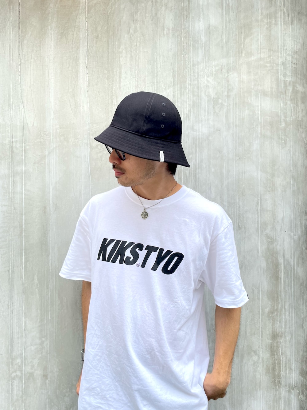 ホワイト系のTシャツ/カットソー、ブラック系のチノパンツ、ブラック系のスニーカーを着用したメンズの夏コーディネートの2枚目の写真