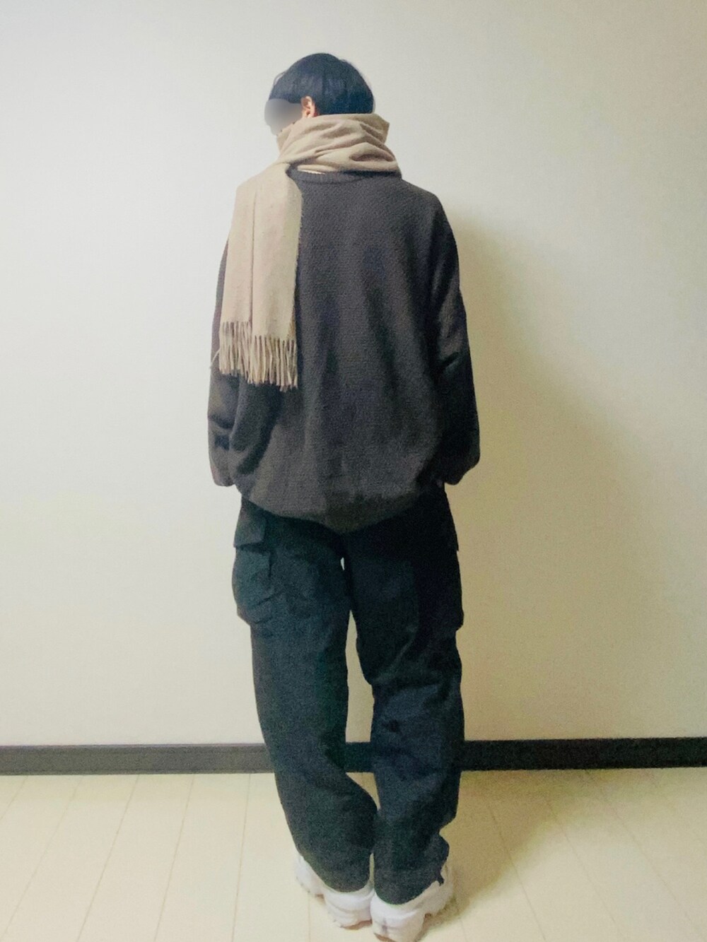 ブラウン系のカーディガン/ボレロ、ベージュ系のTシャツ/カットソー、ブラック系のカーゴパンツを着用したメンズの冬コーディネートの3枚目の写真