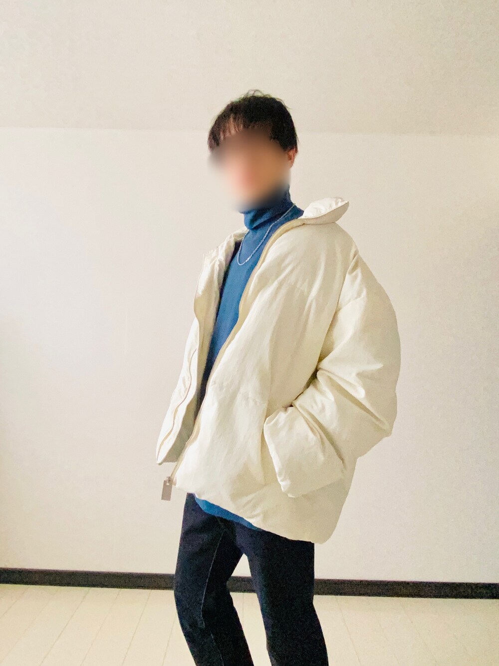 ホワイト系のダウンジャケット/コート、グリーン系のニット/セーター、ブルー系のデニムパンツを着用したメンズの冬コーディネートの3枚目の写真