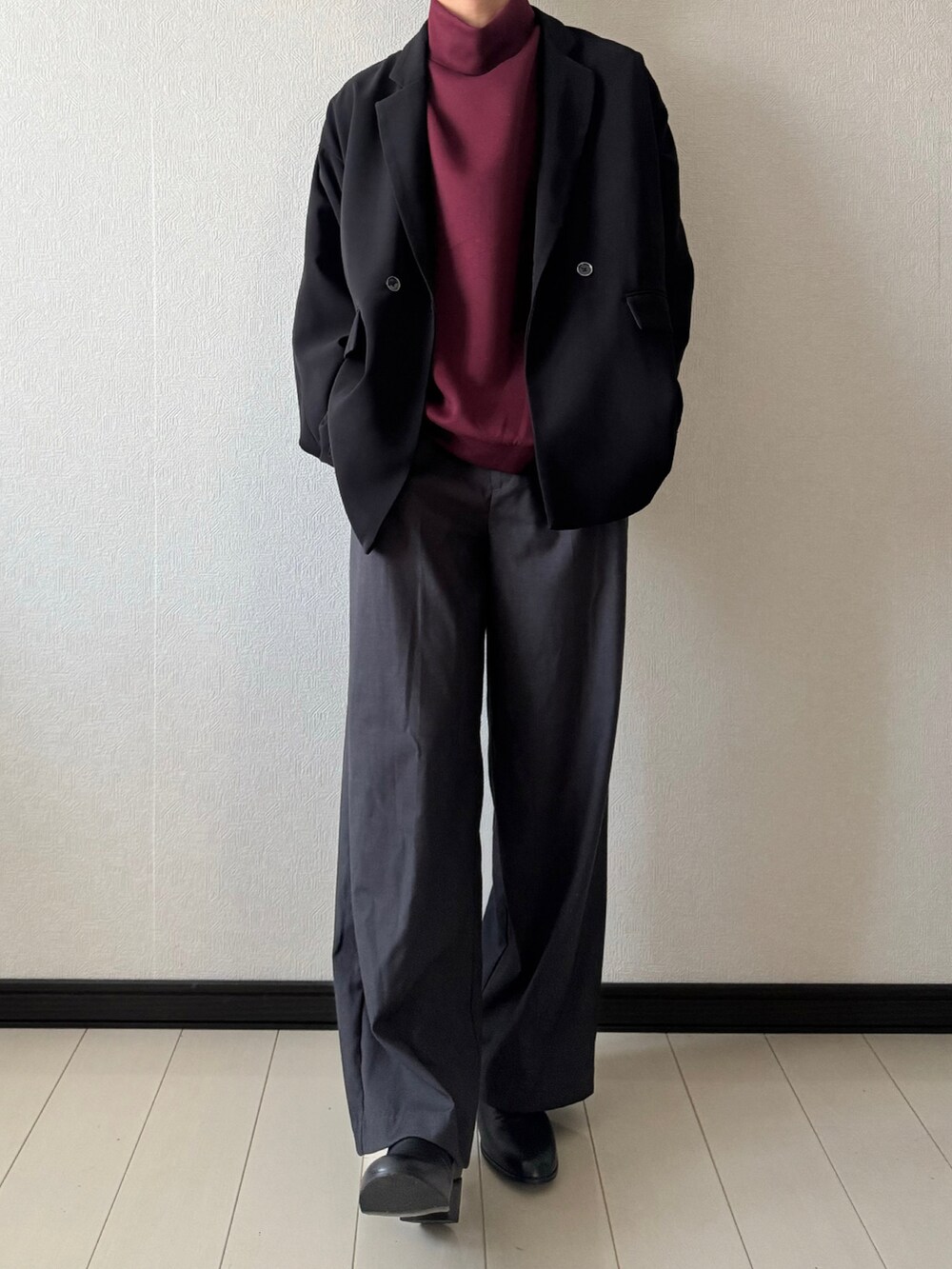 グレー系のスラックス、レッド系のスウェット、ブラック系のテーラードジャケットを着用したメンズの秋コーディネートの2枚目の写真