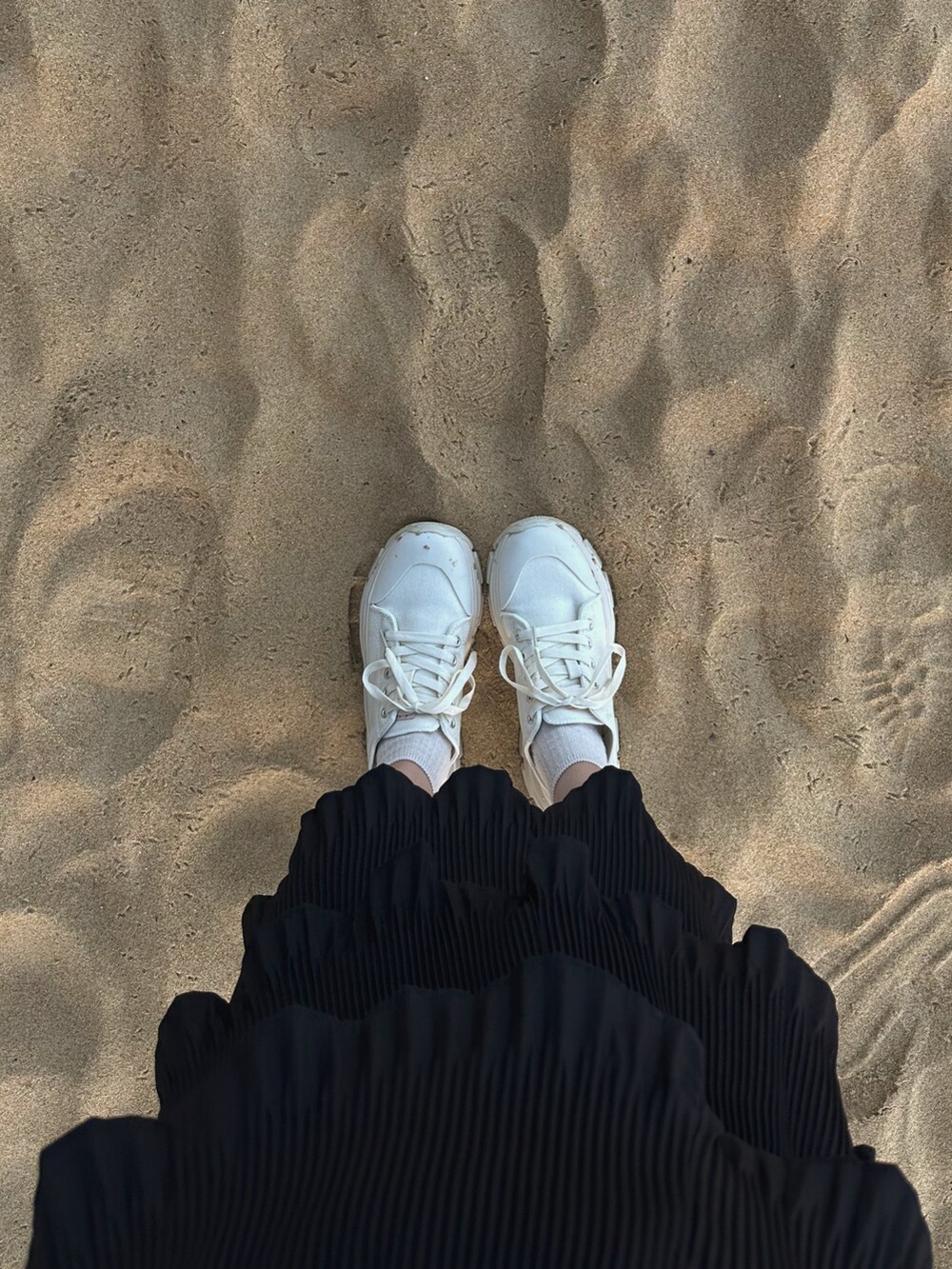 ブラック系のスカート、ホワイト系のシャツ/ブラウス、ホワイト系のスニーカーを着用したレディースの夏コーディネートの2枚目の写真