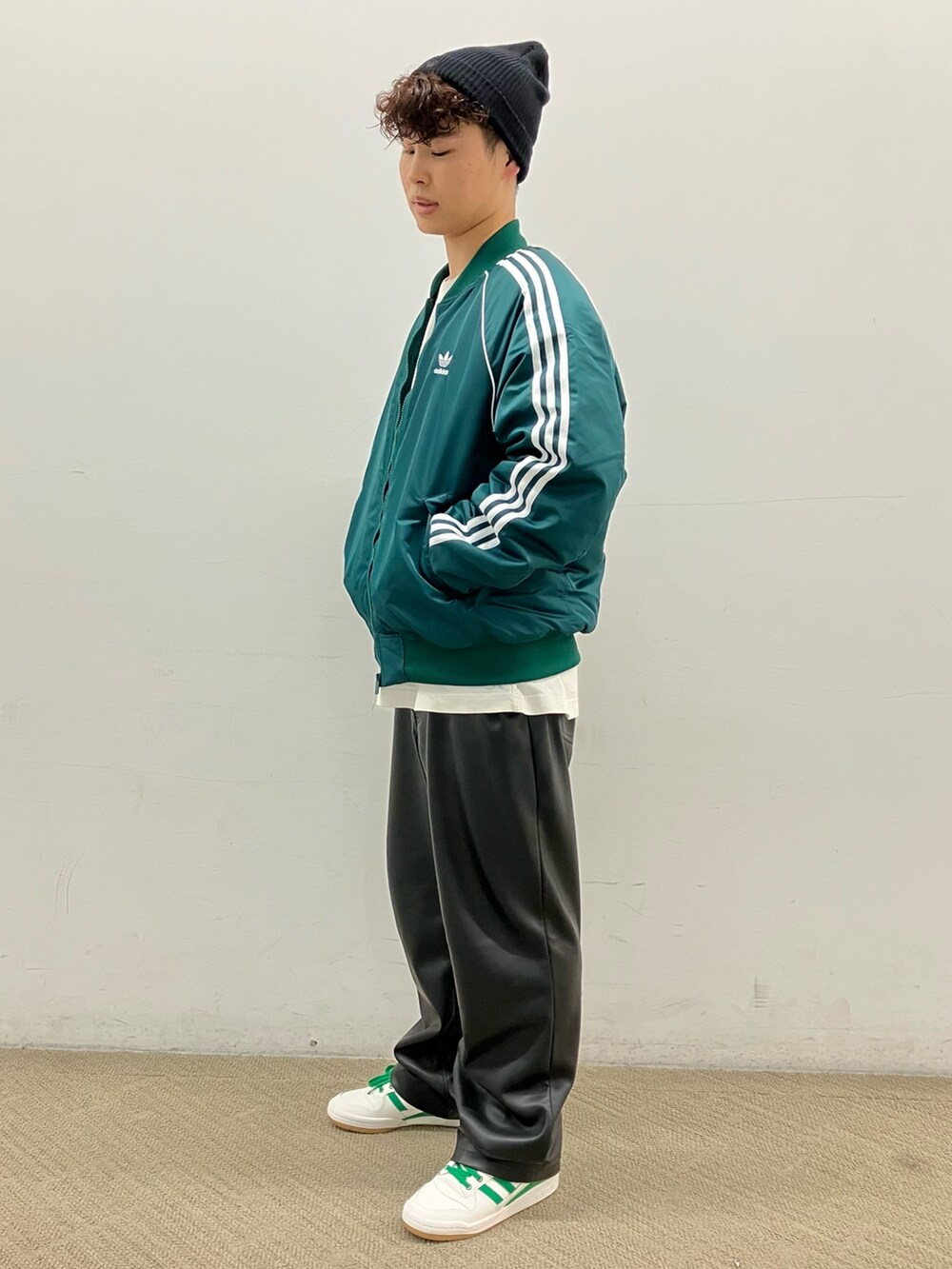 ホワイト系のスニーカー、グリーン系のダウンジャケット/コート、ブラック系のニットキャップ/ビーニーを着用したメンズの秋コーディネートの3枚目の写真