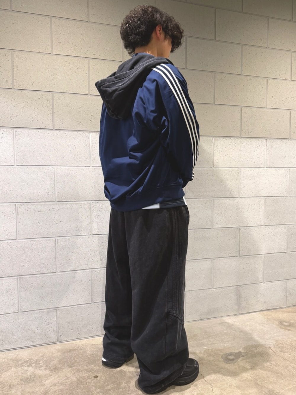 ブラウン系のジャージ、ブラック系のその他パンツ、ブラック系のスニーカーを着用したメンズの冬コーディネートの2枚目の写真