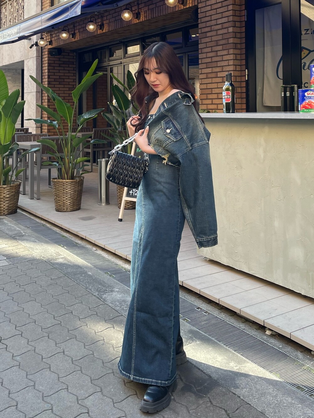 ブラック系のショルダーバッグ、ブルー系のワンピース、ブルー系のデニムジャケットを着用したレディースの冬コーディネートの3枚目の写真