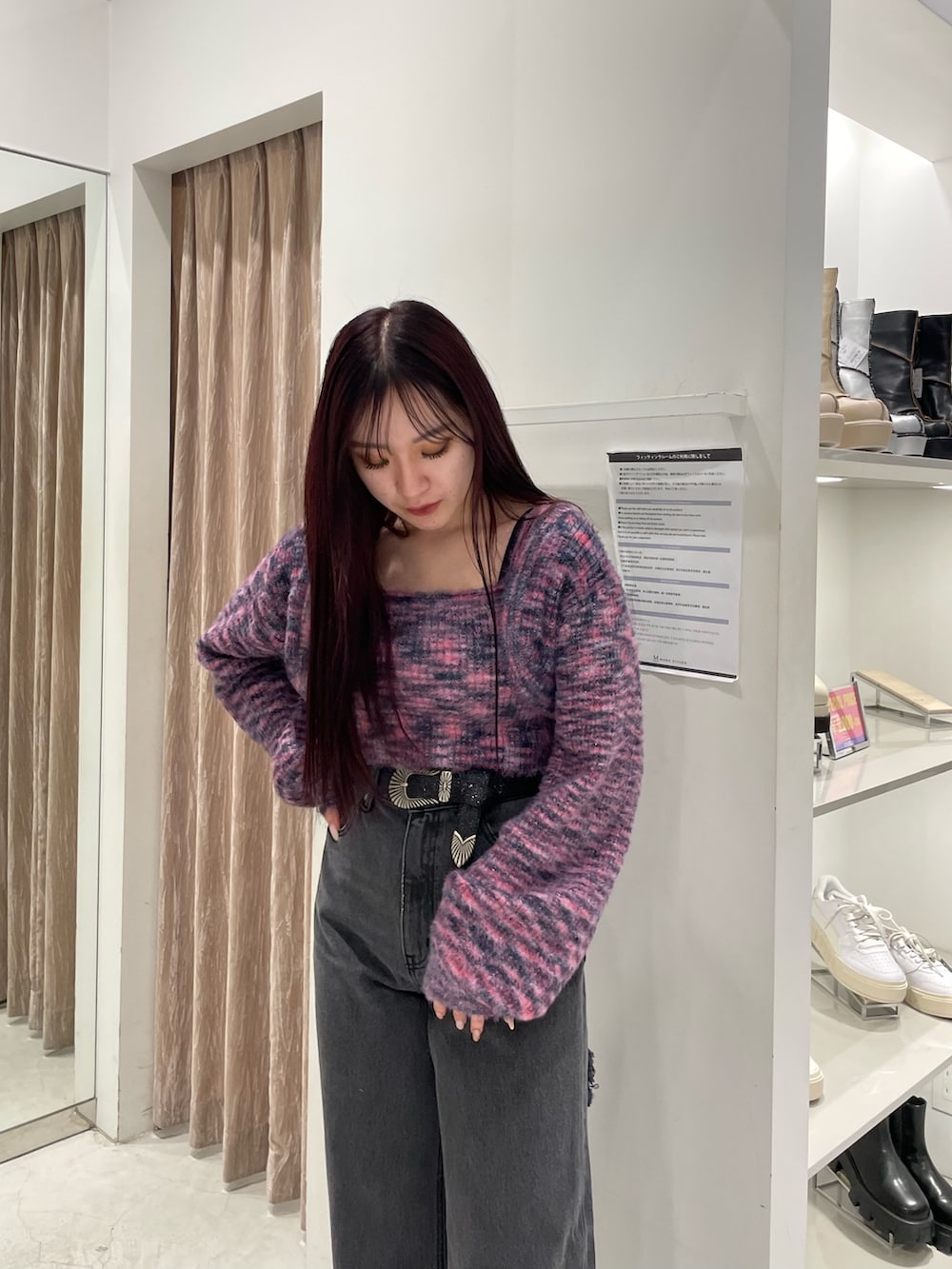 ピンク系のニット/セーター、ブラック系のデニムパンツ、ブラック系のブーツを着用したレディースの冬コーディネートの3枚目の写真