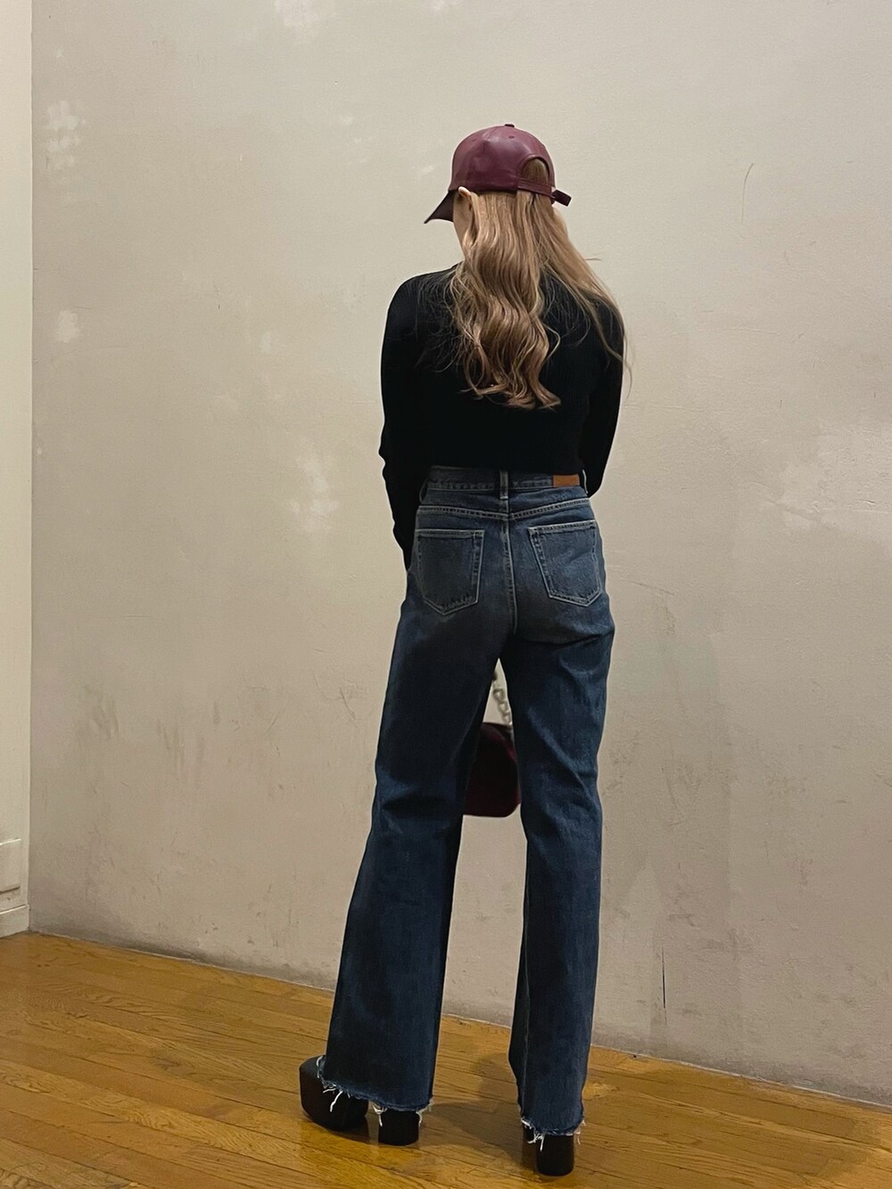 ブルー系のデニムパンツ、パープル系のショルダーバッグ、その他のチェスターコートを着用したレディースの冬コーディネートの4枚目の写真