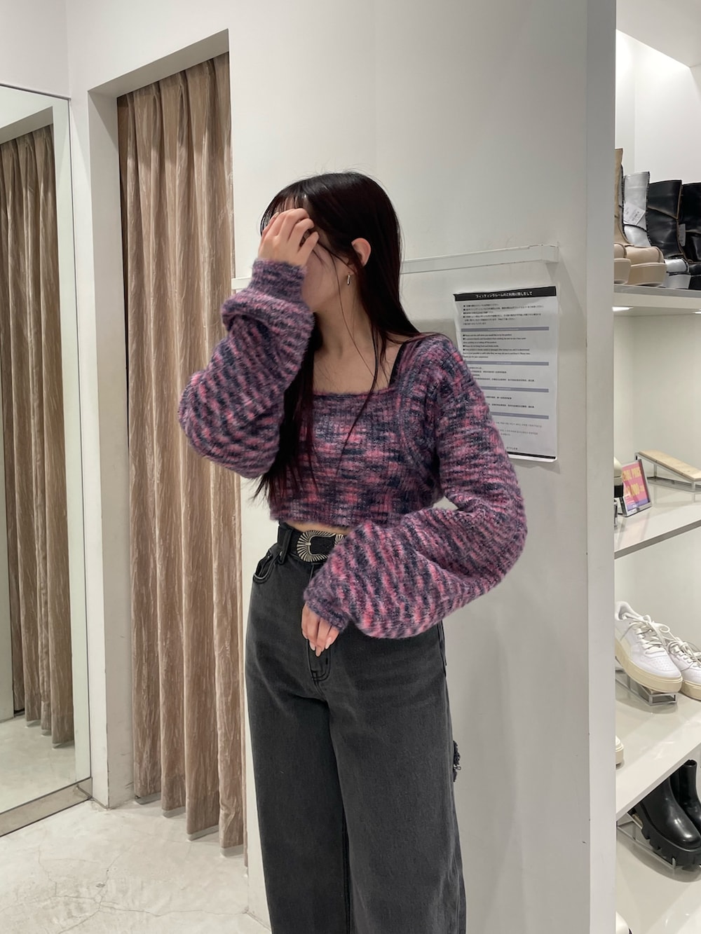 ピンク系のニット/セーター、ブラック系のデニムパンツ、ブラック系のブーツを着用したレディースの冬コーディネートの4枚目の写真