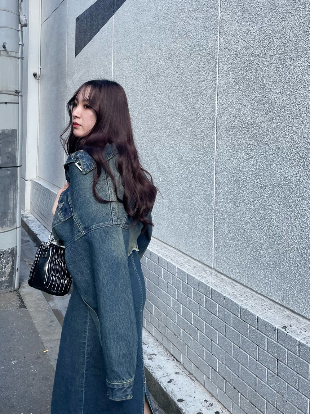 ブラック系のショルダーバッグ、ブルー系のワンピース、ブルー系のデニムジャケットを着用したレディースの冬コーディネートの4枚目の写真