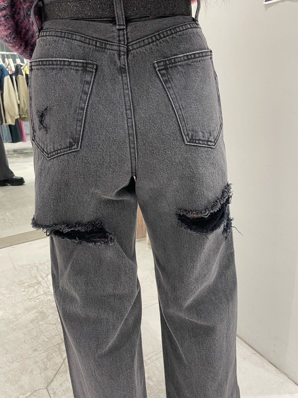 ピンク系のニット/セーター、ブラック系のデニムパンツ、ブラック系のブーツを着用したレディースの冬コーディネートの6枚目の写真