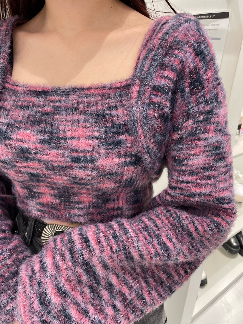 ピンク系のニット/セーター、ブラック系のデニムパンツ、ブラック系のブーツを着用したレディースの冬コーディネートの5枚目の写真