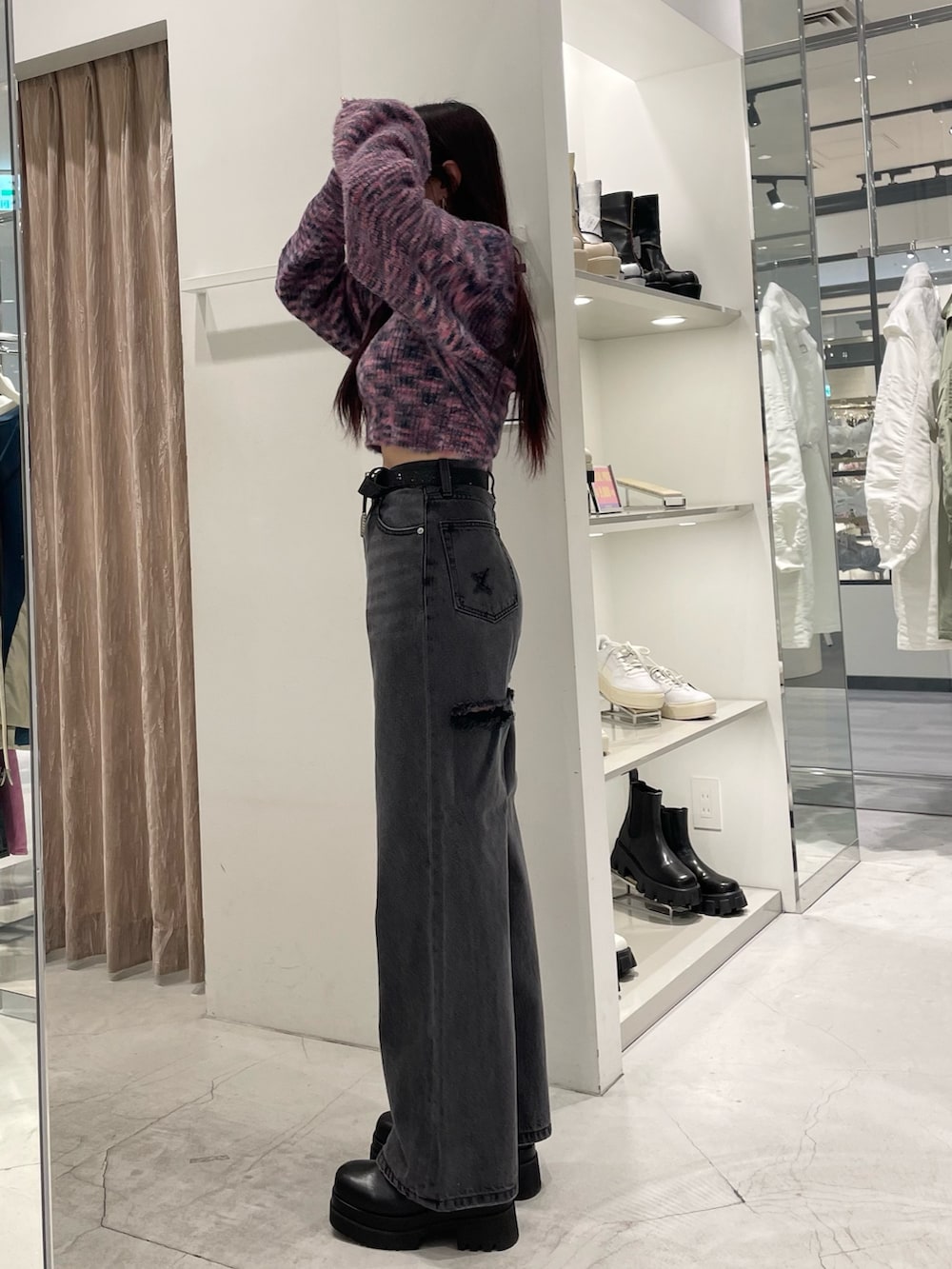 ピンク系のニット/セーター、ブラック系のデニムパンツ、ブラック系のブーツを着用したレディースの冬コーディネートの2枚目の写真