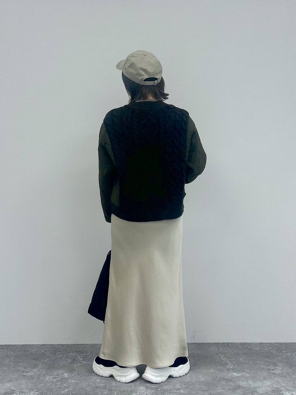 ホワイト系のスカート、グレー系のカーディガン/ボレロ、ブラック系のブーツを着用したレディースの秋コーディネートの6枚目の写真