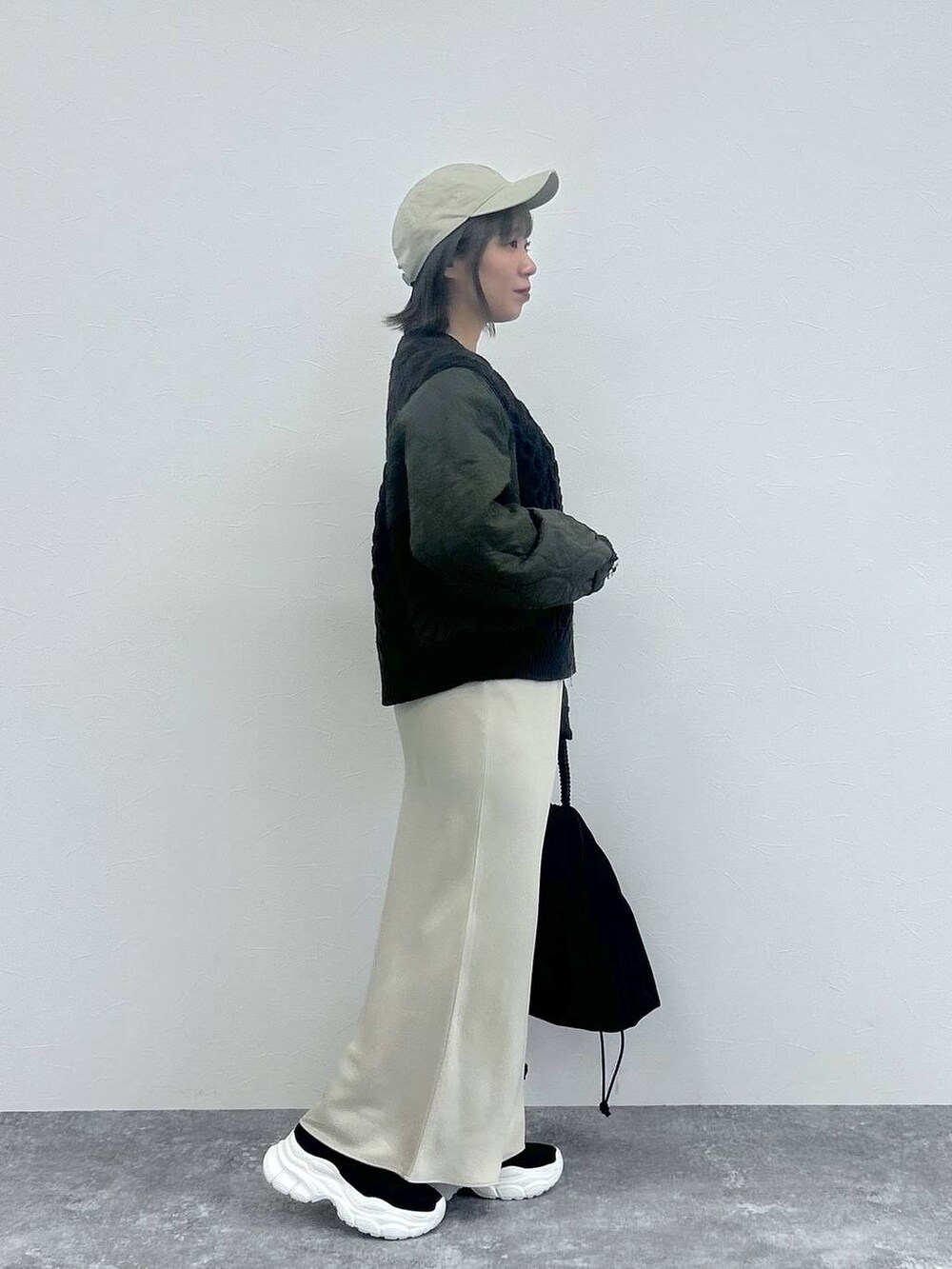 ホワイト系のスカート、グレー系のカーディガン/ボレロ、ブラック系のブーツを着用したレディースの秋コーディネートの5枚目の写真