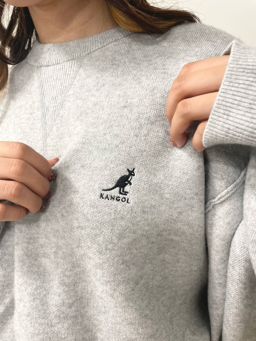 グレー系のニット/セーター、ブラウン系のスニーカー、ブラック系のカーゴパンツを着用したレディースの秋コーディネートの5枚目の写真