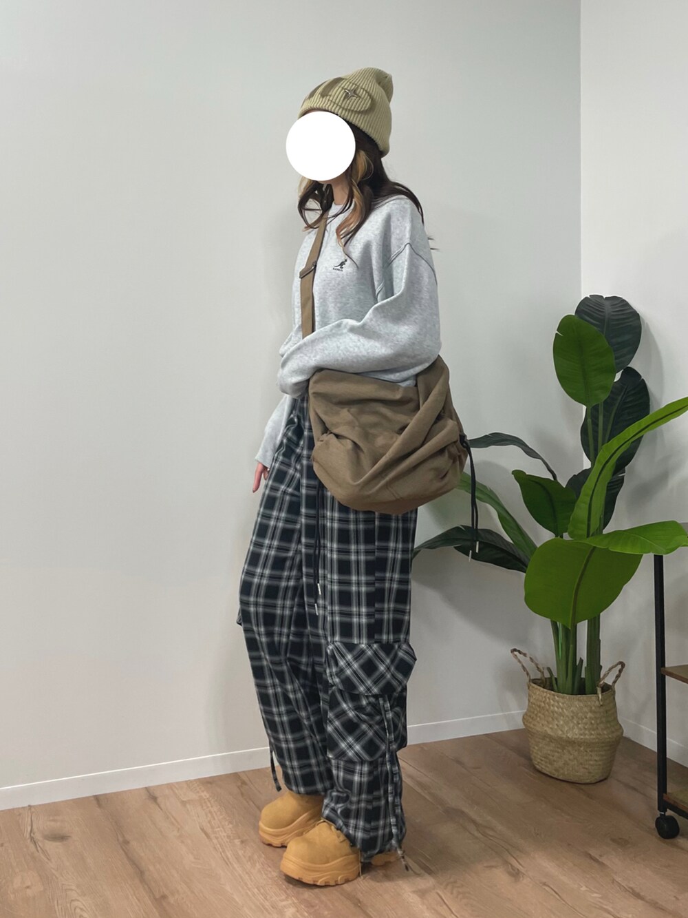 グレー系のニット/セーター、ブラウン系のスニーカー、ブラック系のカーゴパンツを着用したレディースの秋コーディネートの2枚目の写真