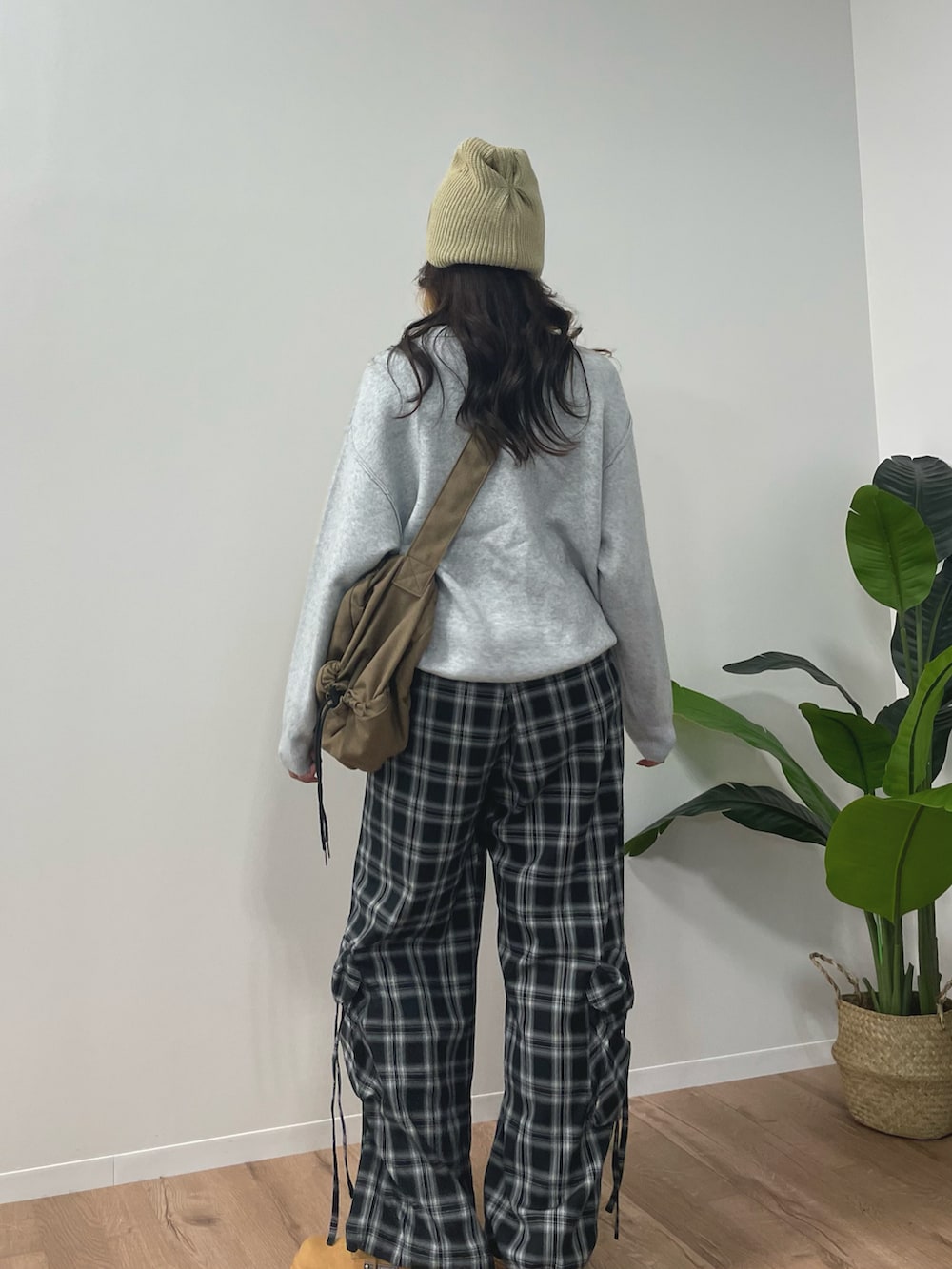 グレー系のニット/セーター、ブラウン系のスニーカー、ブラック系のカーゴパンツを着用したレディースの秋コーディネートの3枚目の写真