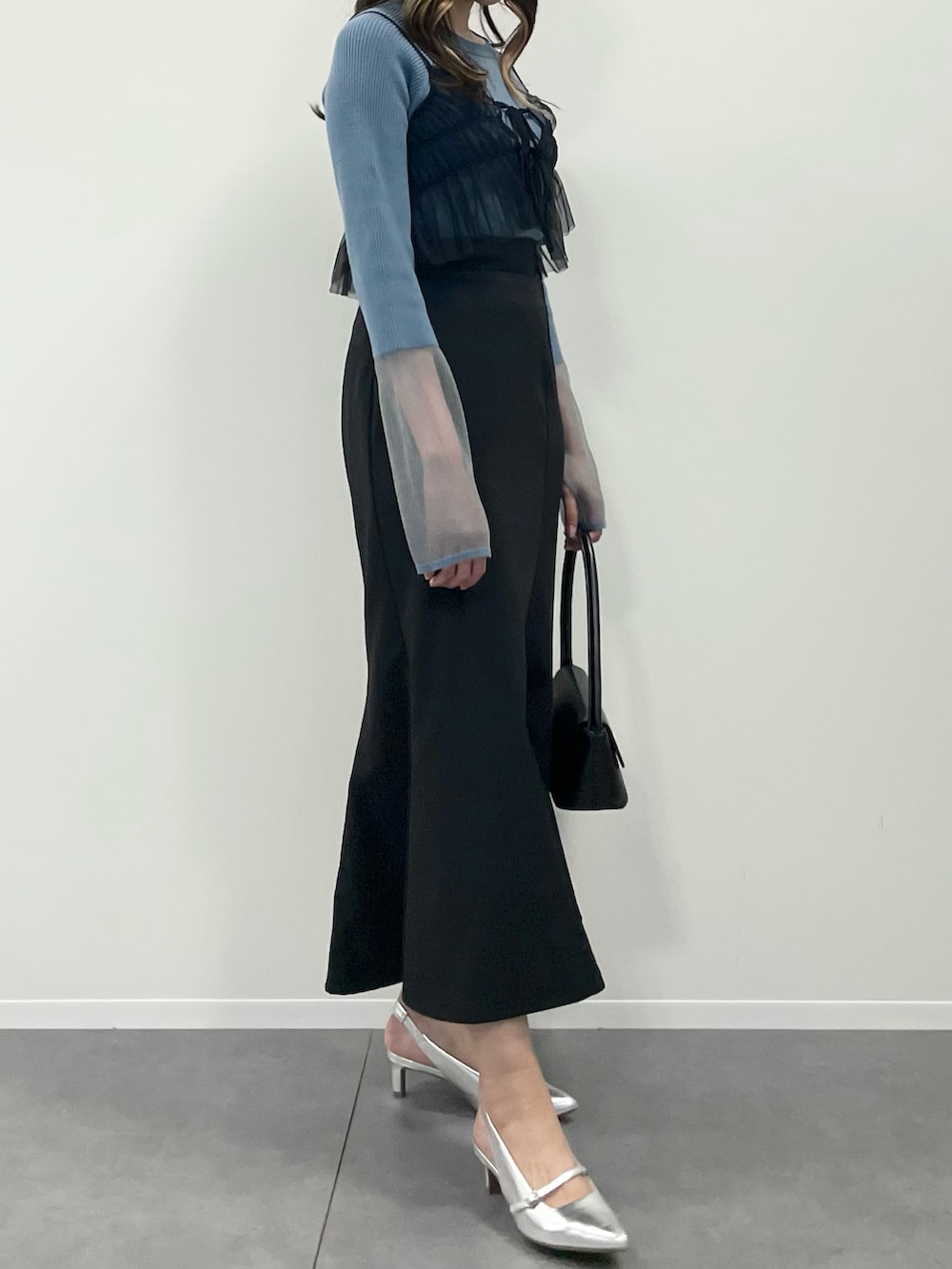 ブラック系のキャミソール、ブラック系のスカート、ブルー系のニット/セーターを着用したレディースの秋コーディネートの2枚目の写真