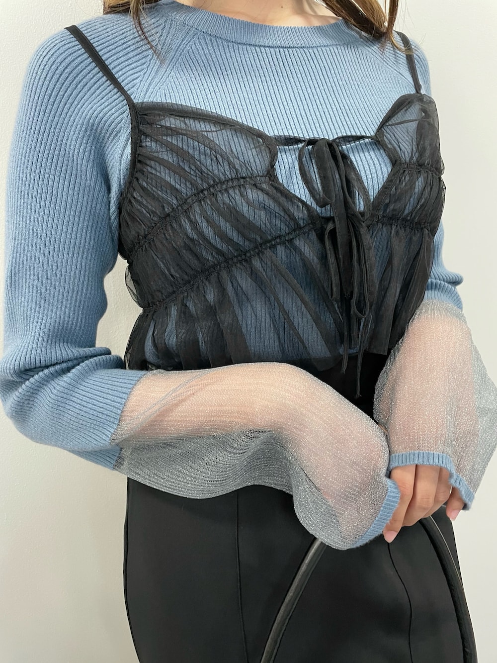 ブラック系のキャミソール、ブラック系のスカート、ブルー系のニット/セーターを着用したレディースの秋コーディネートの4枚目の写真