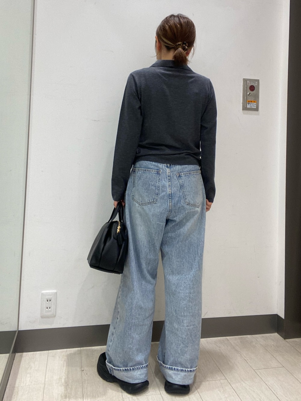 グレー系のニット/セーター、ブルー系のデニムパンツ、ブラック系のボストンバッグを着用したレディースの秋コーディネートの4枚目の写真