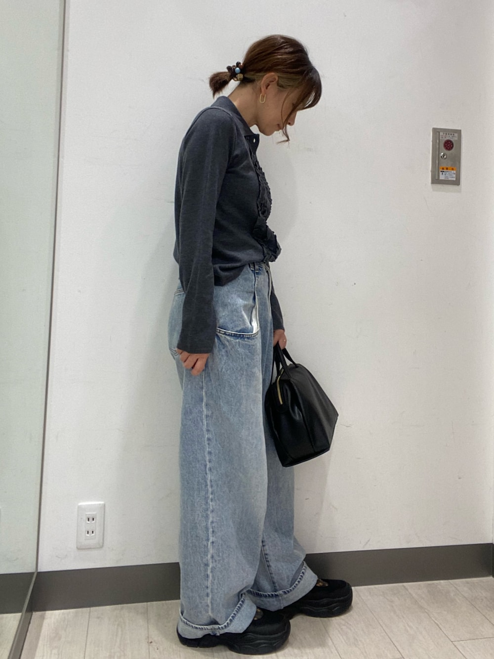 グレー系のニット/セーター、ブルー系のデニムパンツ、ブラック系のボストンバッグを着用したレディースの秋コーディネートの3枚目の写真