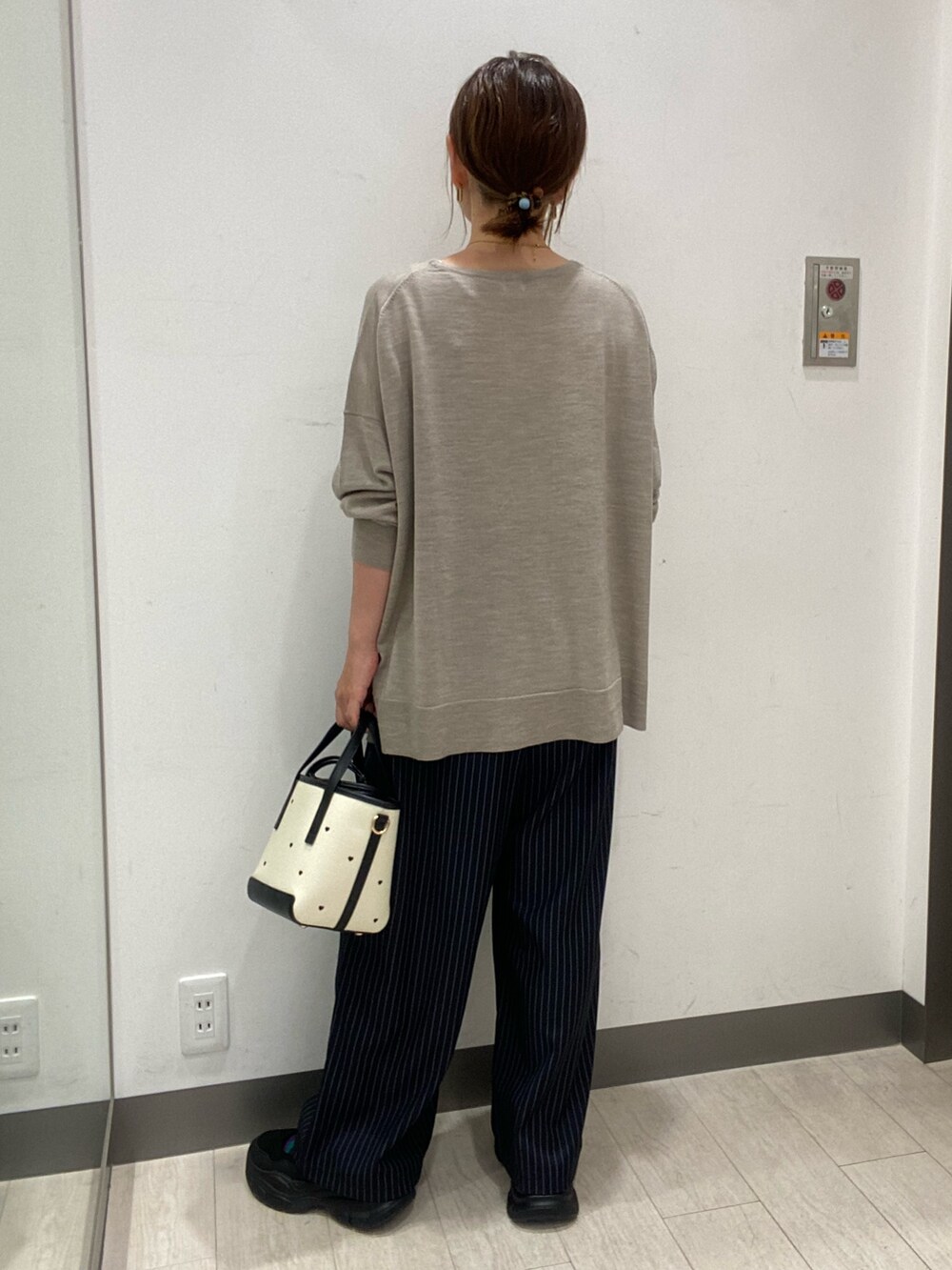 ベージュ系のニット/セーター、ブラック系のハンドバッグ、ブルー系のその他パンツを着用したレディースの秋コーディネートの3枚目の写真