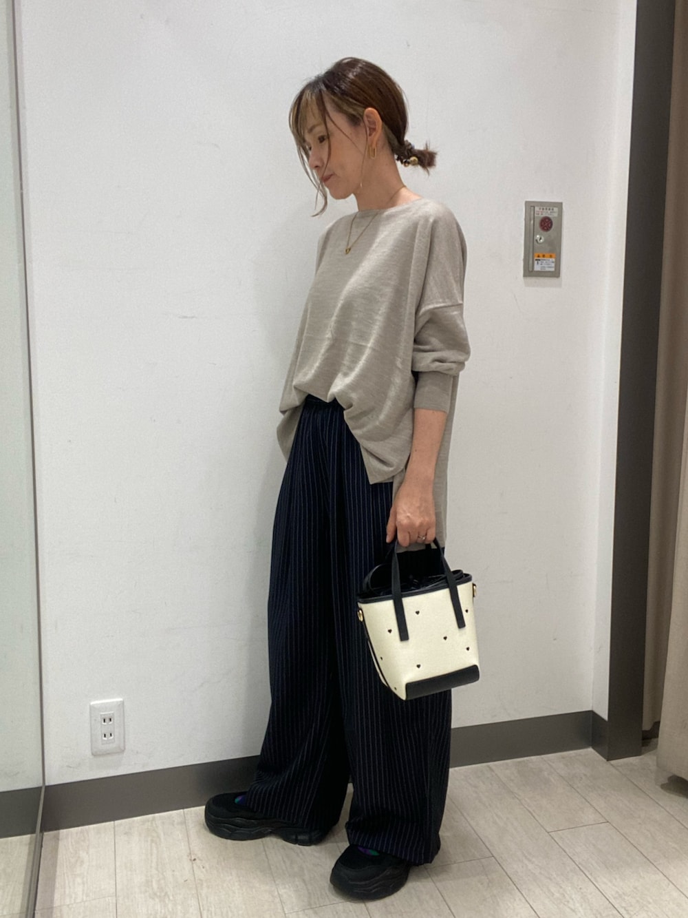 ベージュ系のニット/セーター、ブラック系のハンドバッグ、ブルー系のその他パンツを着用したレディースの秋コーディネートの2枚目の写真