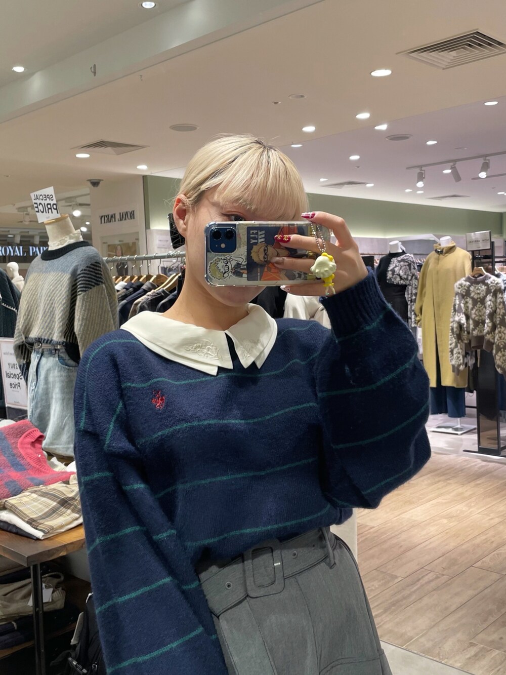 ブルー系のニット/セーター、ホワイト系のシャツ/ブラウス、グレー系のスカートを着用したレディースの冬コーディネートの2枚目の写真