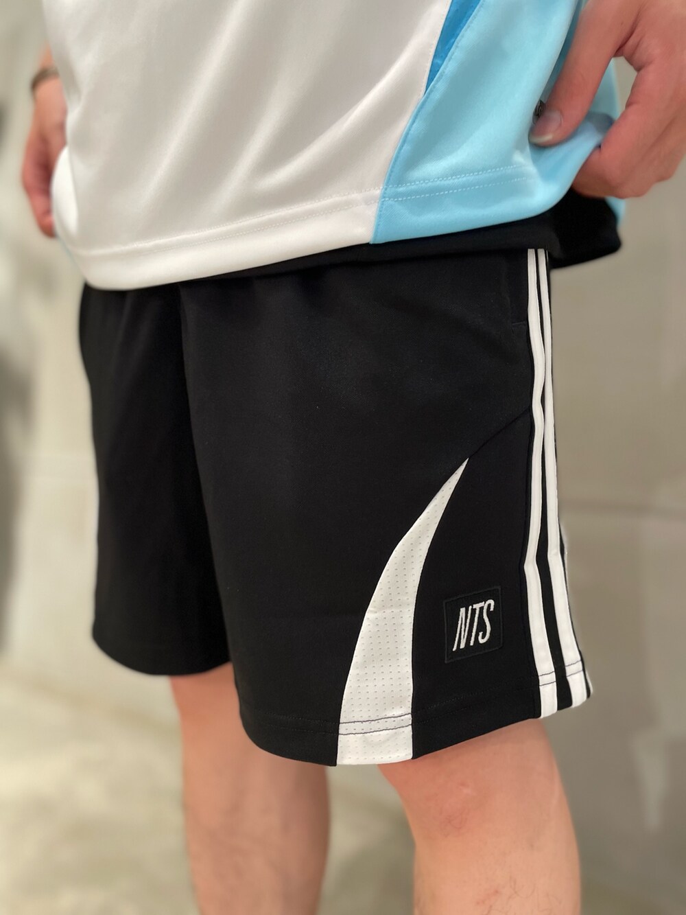 ブルー系のトップス、ブラック系のパンツを着用したメンズの夏コーディネートの4枚目の写真