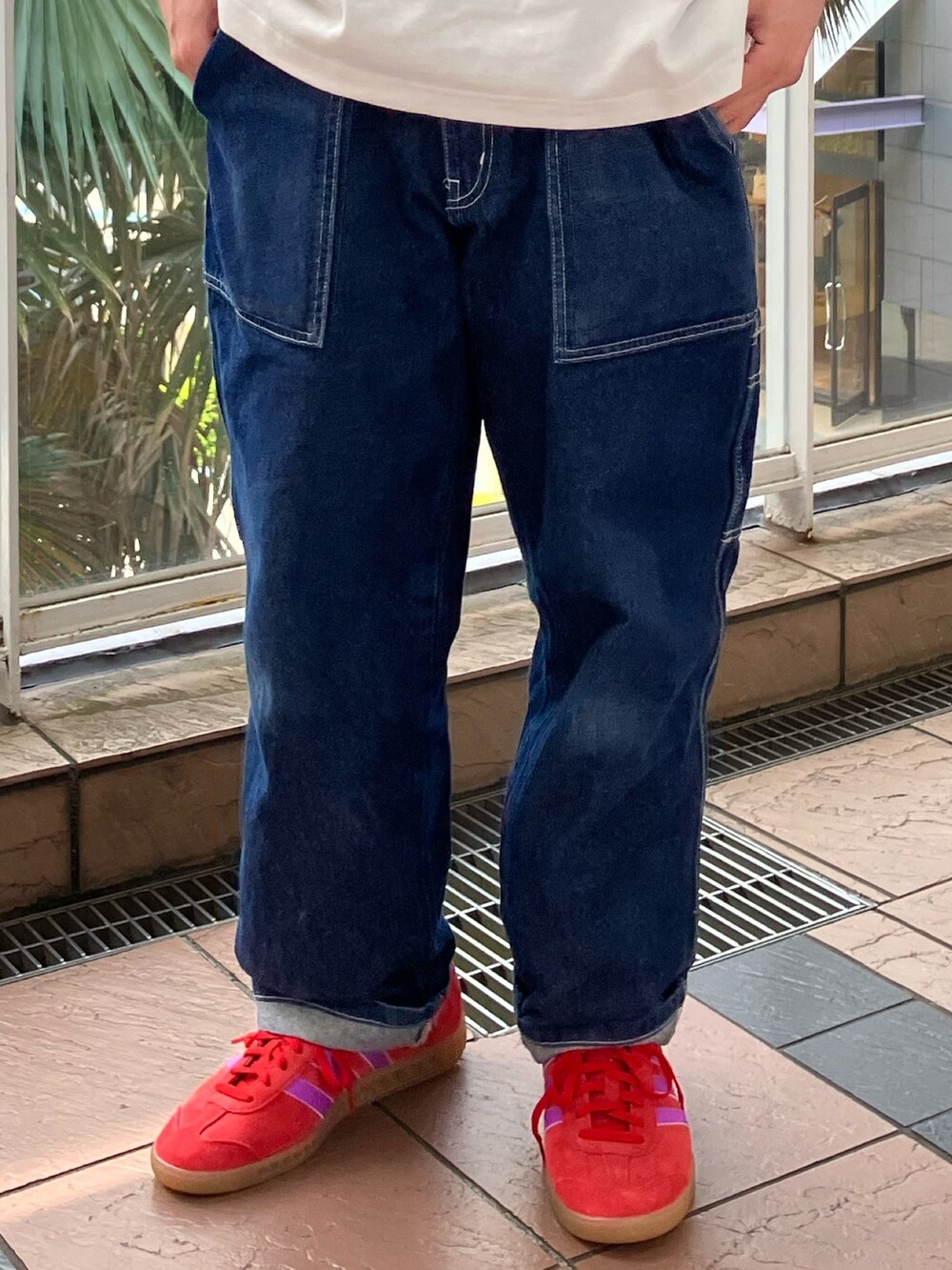 ホワイト系のトップス、レッド系のシューズを着用したメンズの春コーディネートの2枚目の写真