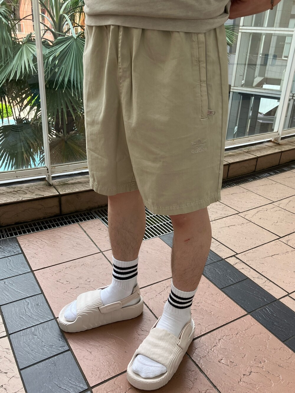 ベージュ系のTシャツ/カットソー、ベージュ系のその他パンツ、ベージュ系のサンダルを着用したメンズの春コーディネートの3枚目の写真