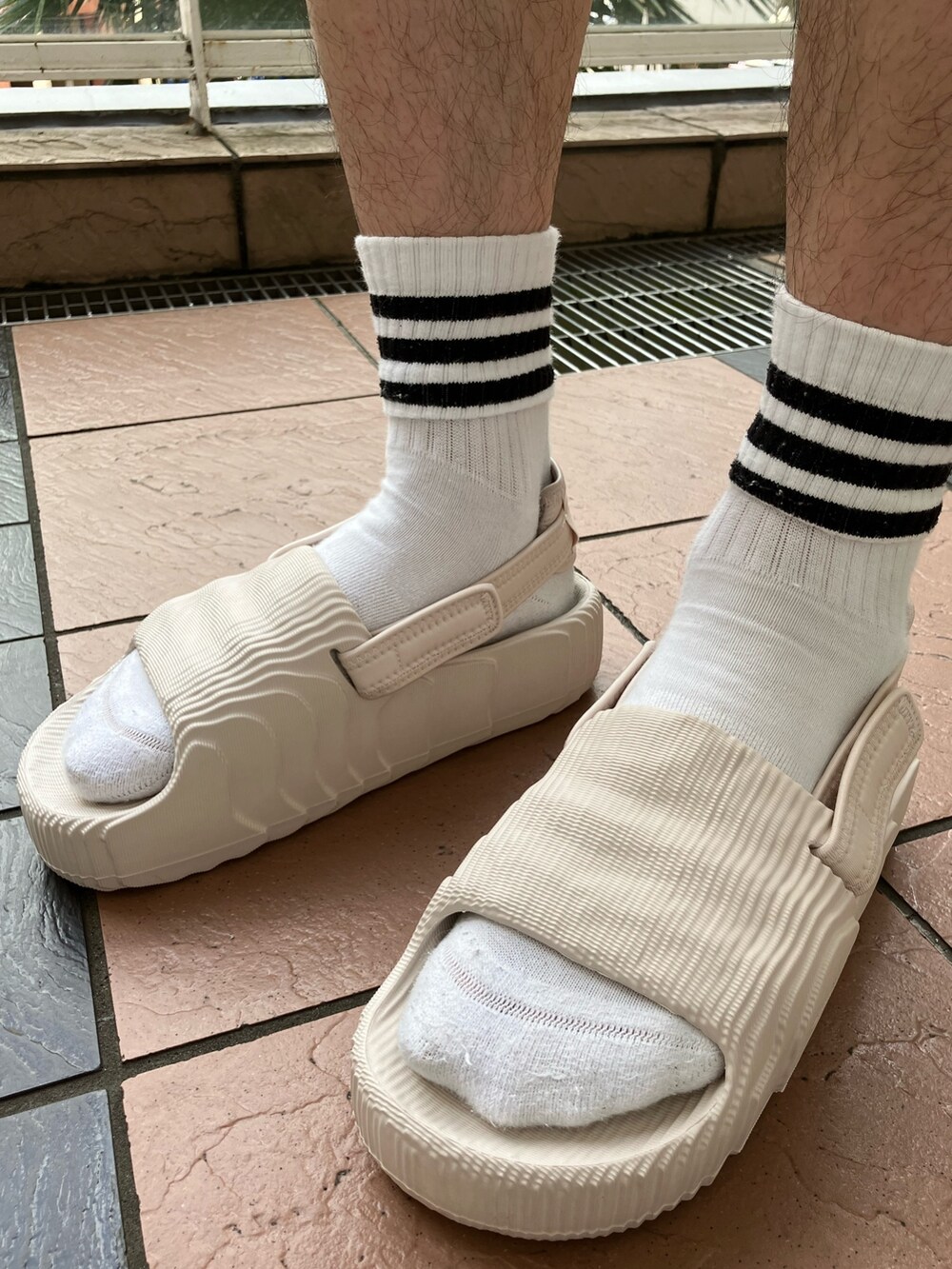 ベージュ系のTシャツ/カットソー、ベージュ系のその他パンツ、ベージュ系のサンダルを着用したメンズの春コーディネートの4枚目の写真